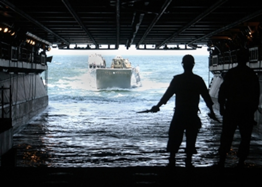 U.S. Navy sailors guide a Landing Craft Utility boat into the flooded well deck of the USS Kearsarge (LHD 3) to offload equipment and supplies as the ship operates in the Atlantic Ocean on Aug. 15, 2006.  The amphibious assault ship is participating in exercise Panamax '06, a multinational training exercise, involving the United States, Central and South American countries, and Caribbean nations.  