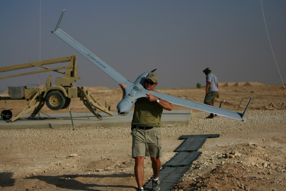 Tim Hall carries a ScanEagle to put it away after retrieving it from a flight with the "Skyhook" in the Al Anbar Province of Iraq, Aug. 17. Hall is a field service representative for The Insitu Group and is currently on a service contract for the Marine Corps, flying aerial surveillance missions over Iraq for the troops on the ground. He is one of the main operators and maintainers of the ScanEagle for Marine Unmanned Aerial Vehicle Squadron 2, Marine Air Control Group 38 (Reinforced), 3rd Marine Aircraft Wing (Forward).