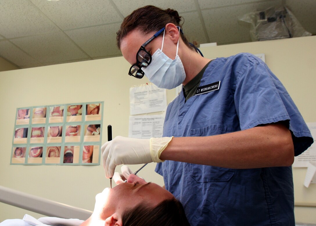 MARINE CORPS BASE CAMP LEJEUNE, N.C. -- -- Navy Lt. Kirsten A. Wisniakowski of Renton, Wash., Naval Dental Officer, 2nd Dental Battalion., 2nd Marine Logistics Group, performs an examination on a walk-in patient Aug 17. The dental officer offers services similar to those performed by civilian dentists and orthodontists.