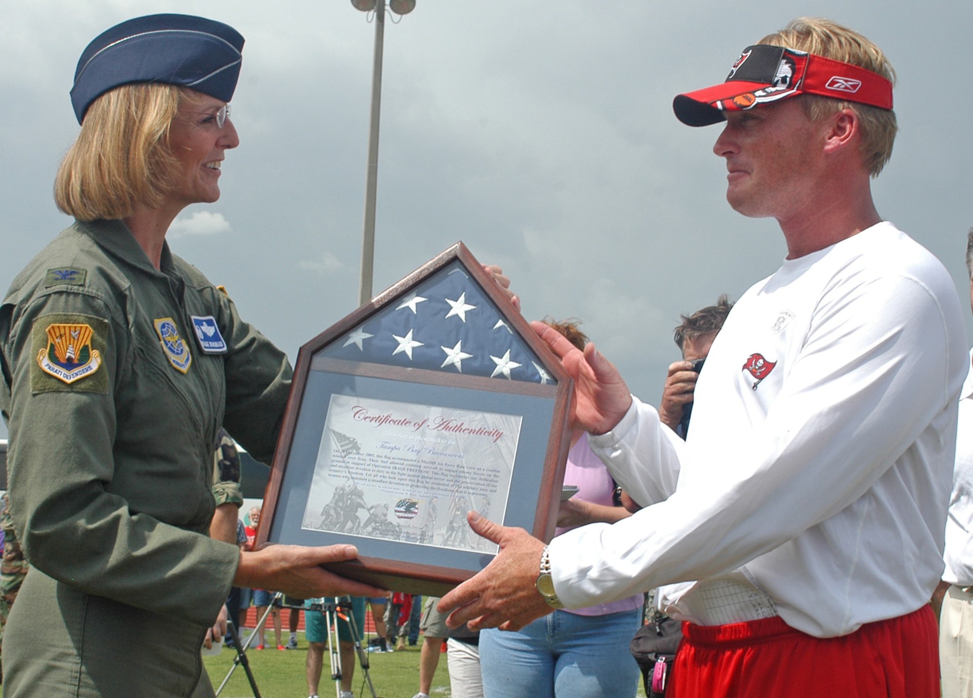 Col. Maggie Woodward, 6th Air Mobility Wing commander, presents a framed flag to Jon Gruden, Tampa Bay Buccaneers head coach, after the pre-game, walkthrough practice held at MacDill Air Force Base, Fla., on Aug. 18. The practice was closed to the general public but open to base personnel. Airmen who attended the practice were able to get an up-close look at the 2006 Buccaneers team. (U.S. Air Force photo/Staff Sgt. Randy Redman) 