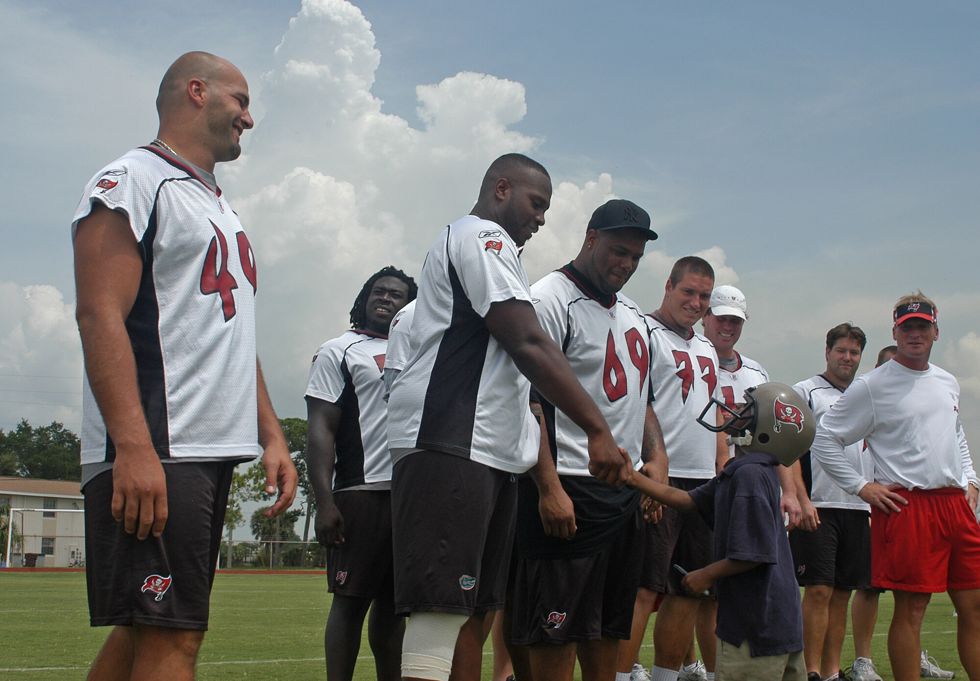 James Lyons, 7, shakes hands with linemen from the Tampa Bay Buccaneers during the pre-game, walkthrough practice held at MacDill AFB, Fla., Friday, Aug. 8. Friday’s practice was open to base personnel but closed to the general public.