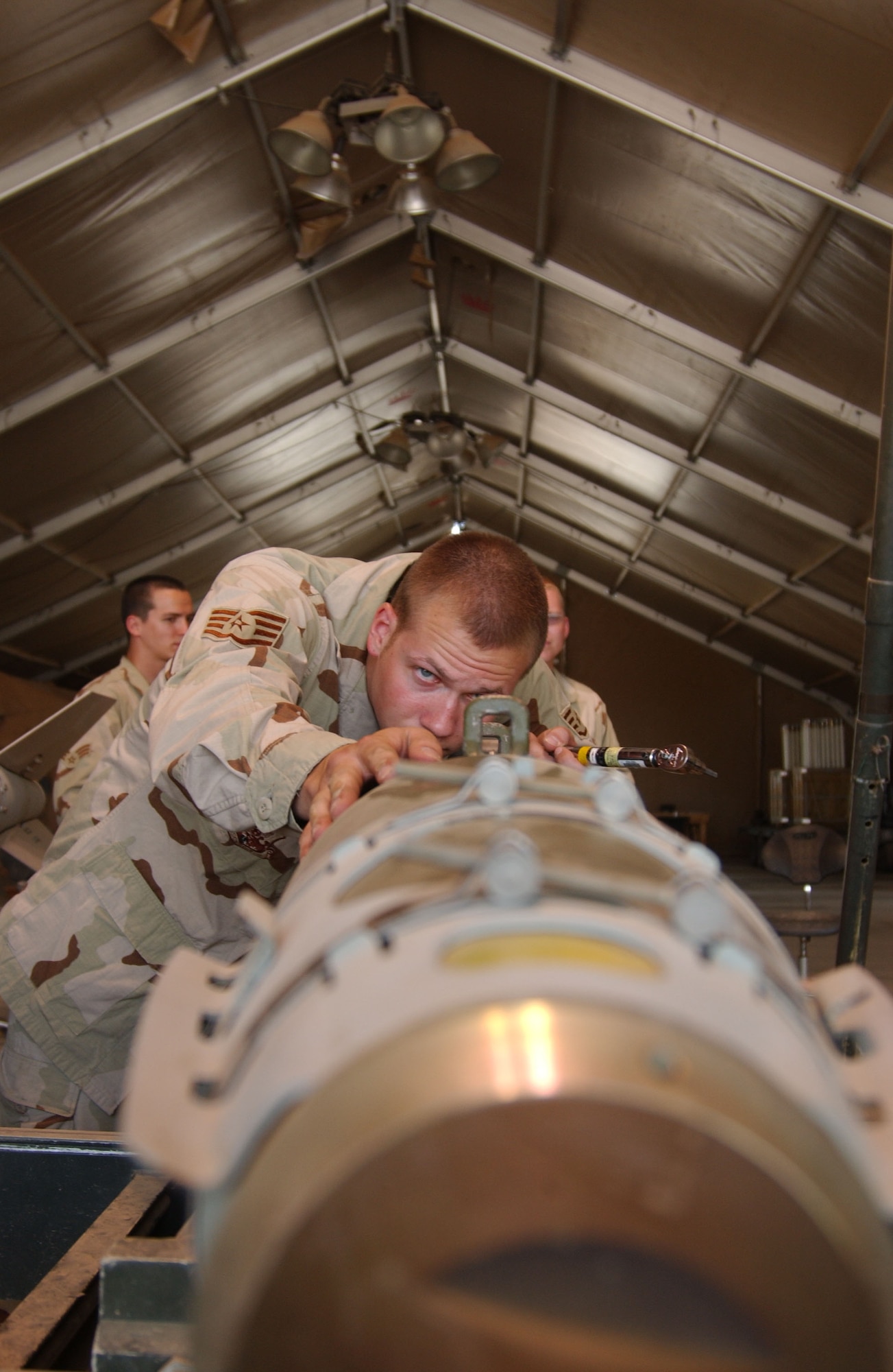 Staff Sgt. Joshua Rankin checks the alignment of posts used to attach a Guided Bomb Unit-38 to an F-16 Fighting Falcon. Sergeant Rankin is from the Ohio Air National Guard's 180th Fighter Wing in Perrysburg. (U.S. Air Force photo/Senior Airman Kerry Solan-Johnson)

