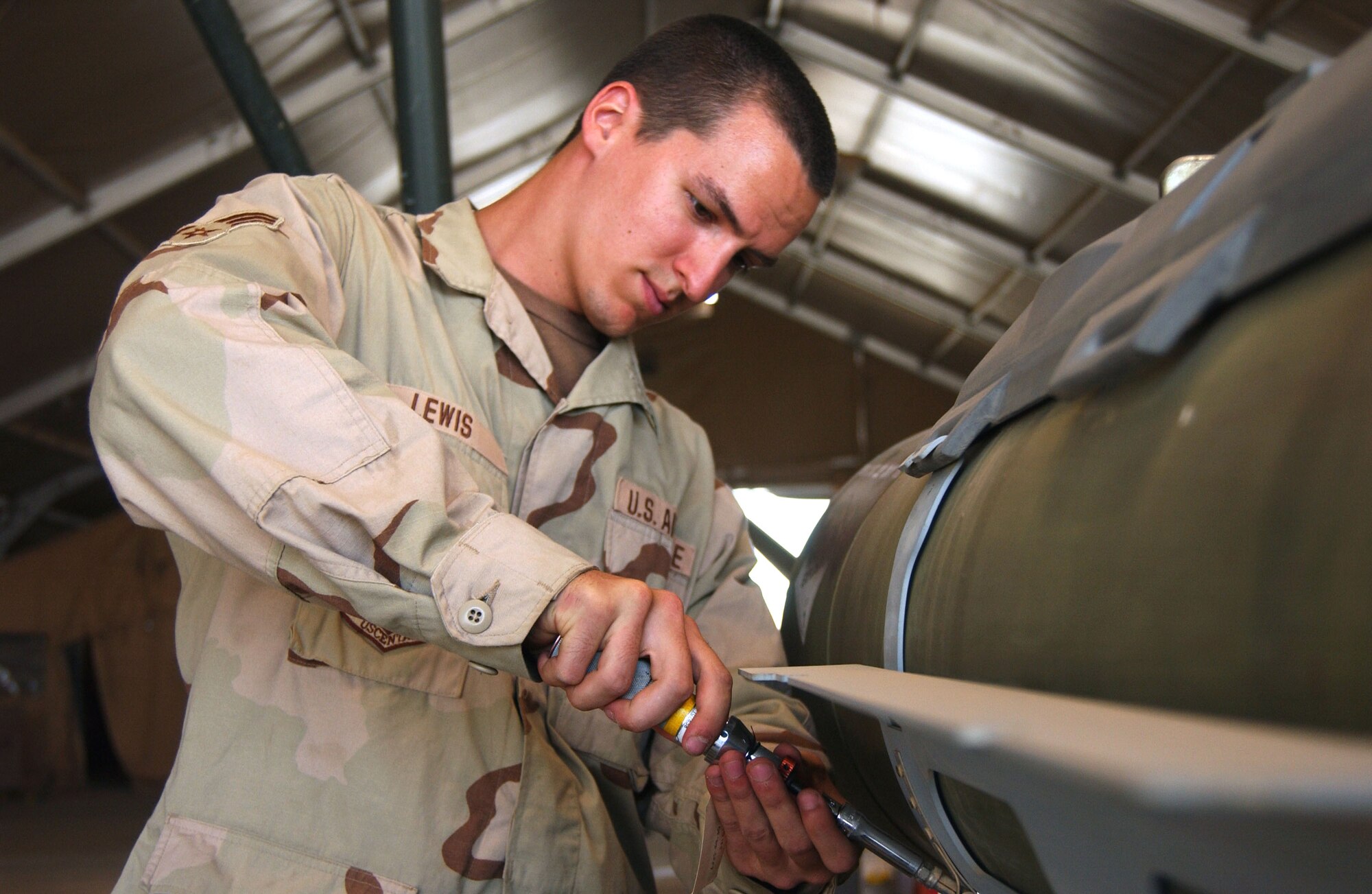 Airman 1st Class Joseph Lewis checks the tension of the tail assembly on a Guided Bomb Unit-38. The munitions flight attaches components to the same general purpose bombs used in Vietnam, turning them into modern precision weapons. Airman Lewis is from the Ohio Air National Guard's 180th Fighter Wing in Perrysburg. (U.S. Air Force photo/Senior Airman Kerry Solan-Johnson) 