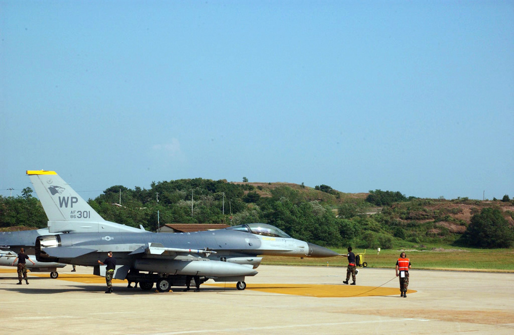 Airmen prepare an F-16 Fighting Falcon for takeoff at Kunsan Air Base, South Korea, on Aug. 16. The fighter squadrons here fired live AIM-9 Sidewinder missiles at flares dropped by A-10 Thunderbolt IIs from Osan AB, South Korea. (U.S. Air Force photo/Tech. Sgt. Jeffrey Allen) 