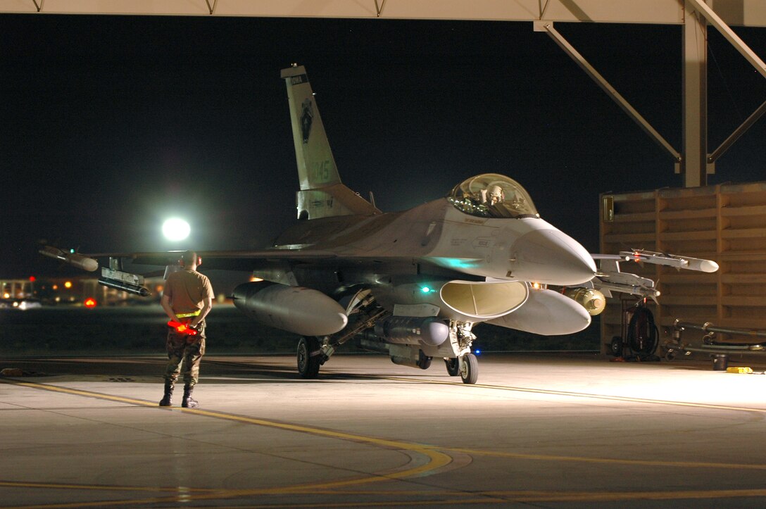 Tech. Sgt. Mike Johanns waits to marshal an F-16 Fighting Falcon during Red Flag 06-02 at Nellis Air Force Base, Nev., on Aug. 15. U.S. and coalition servicemembers are participating in the exercise that concludes today. Sergeant Johanns is a crew chief with the Iowa Air National Guard's 132nd Fighter Wing. (U.S. Air Force photo/Tech. Sgt. Bob Sommer) 

