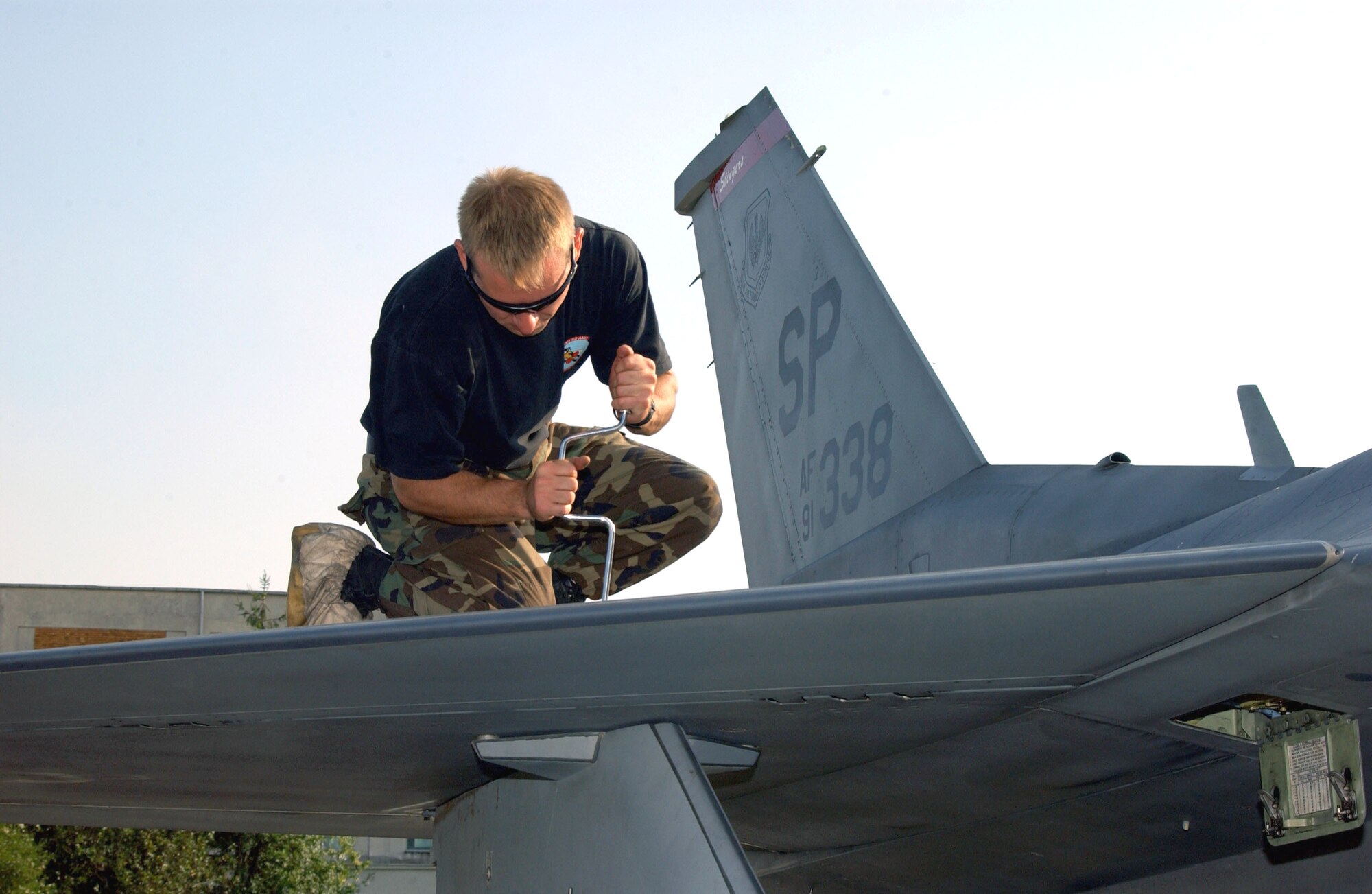 Senior Airman Ben Polichnowski removes a bolt on an F-16 Fighting Falcon external wing tank on Aug. 18 during Exercise Viper Lance 2006 at Mihail Kogalniceanu Air Base, Romania. Airman Polichnowski is a crew chief with the 22nd Expeditionary Fighter Squadron. (U.S. Air Force photo/Senior Airman Eydie Sakura)