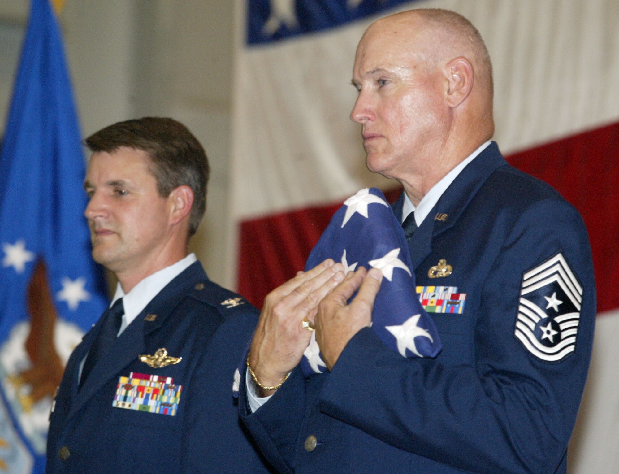 94th Airlift Wing Command Chief James Michael West holds the retirement flag given to him during his retirement ceremony on the August unit training assembly.  To his right, Col. Heath Nuckolls, 94th Airlift Wing commander, officiated the ceremony.