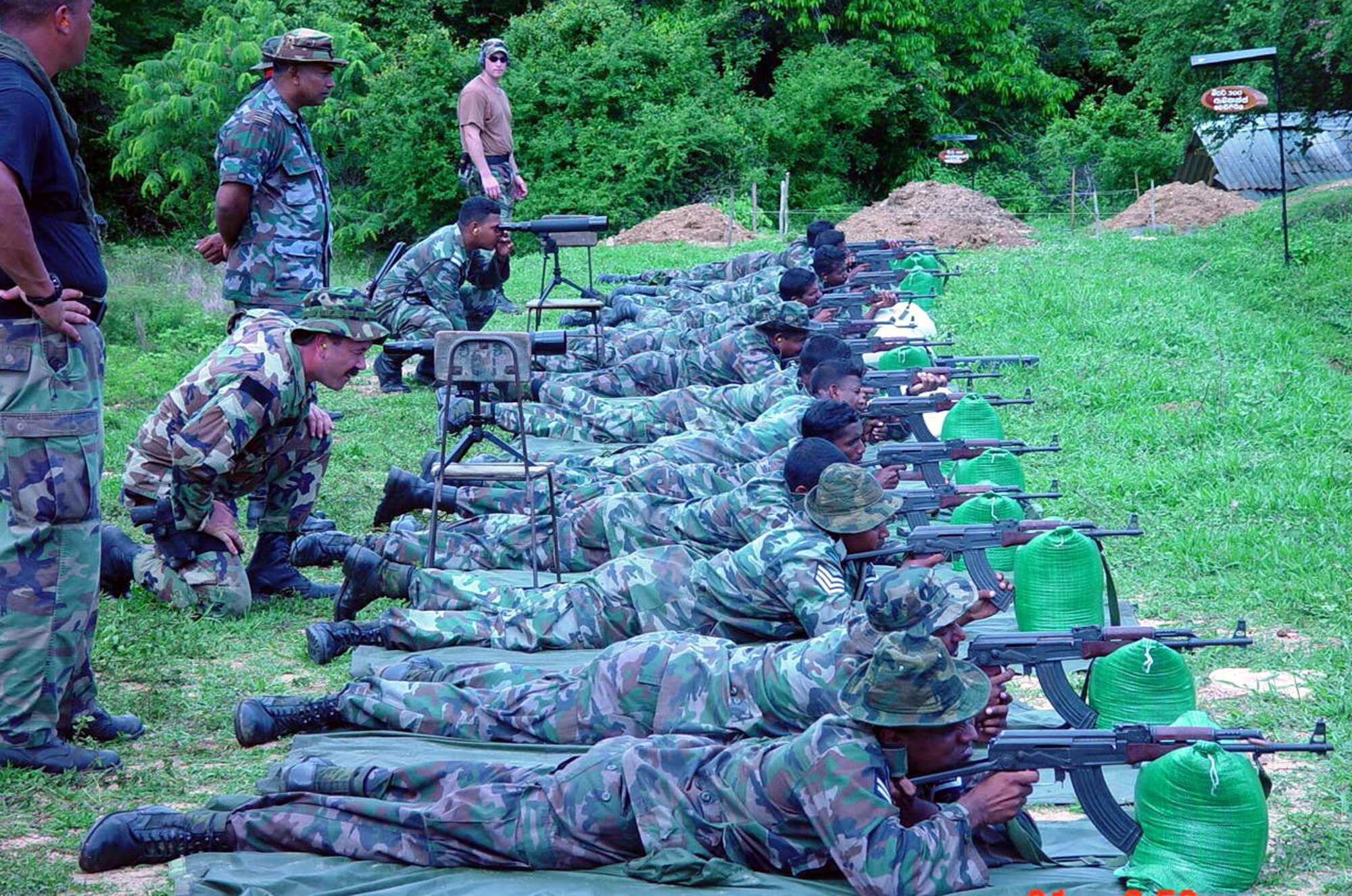 Several combat aviation advisors from the 6th Special Operations Squadron observe as members of a host nation in the Pacific Command area of responsibility practice shooting AK-47 rifles. (Courtesy Photograph)