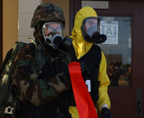 Dyess Air Force Base, TX - Two Airman in full MOP gear held the ribbon for Colonel Timothy Ray,  at a ribbon cutting ceremony to celebrate the newly renovated CES readiness shop                     