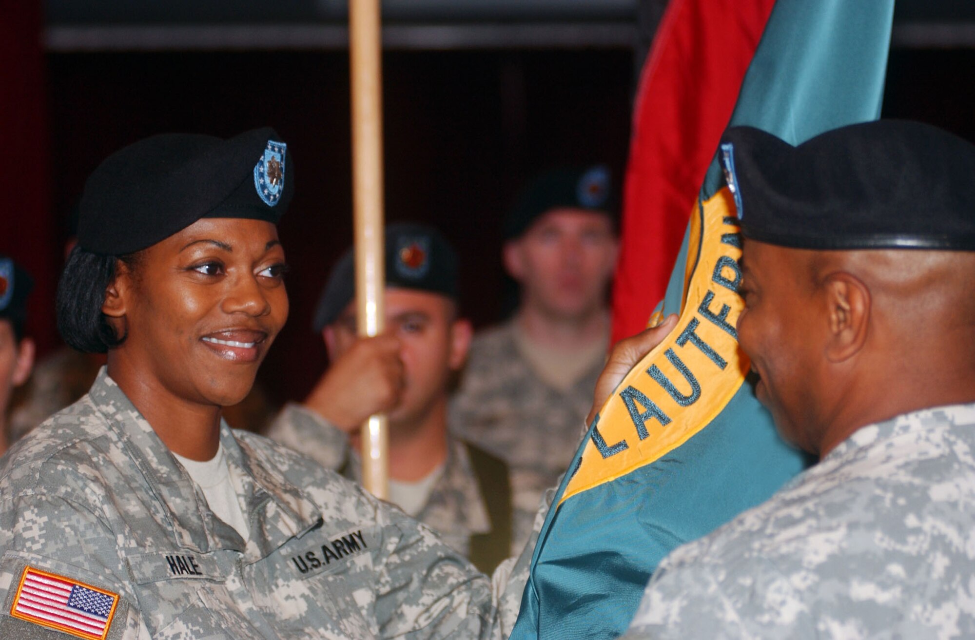 Lt. Col. Mechelle B. Hale, U.S. Army Garrison Kaiserslautern commander, accepts the Garrison Organizational Colors from Col. Willie E. Gaddis, USAG Heidelberg commander, in a change-of-command ceremony Aug. 10 at the Armstrong Community Club on Vogelweh Housing in Kaiserslautern.