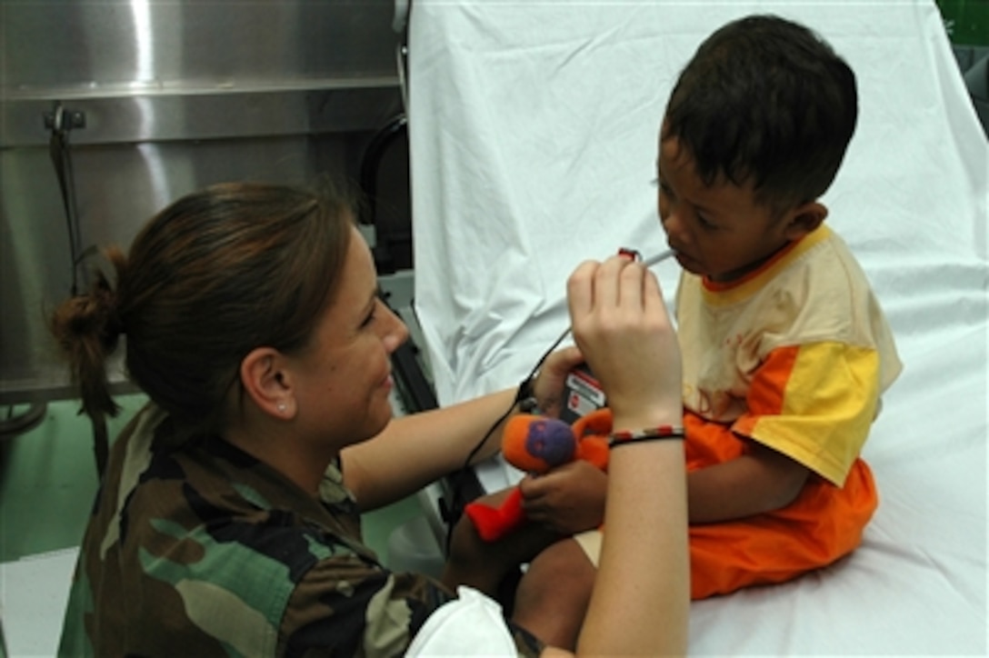 U.S. Air Force Senior Airman Kristen Lynch checks a patient's temperature in the casualty receiving area aboard the Military Sealift Command hospital ship USNS Mercy (T-AH 19) during the ship's visit to Tarakan, Indonesia, on Aug. 15, 2006.  The Mercy is conducting humanitarian and civic assistance missions during its five-month deployment to South Asia, Southeast Asia and the Pacific Islands.  