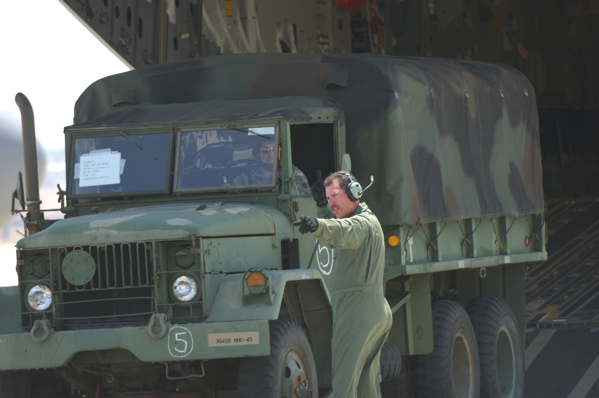 Trucks and Humvees are off-loaded and marshalled from the  C-17 Globemasters III returning from Pt. Mugu Naval Air Station. The five C-17"s airlifted the 304 Sustainment Brigade from Pt Mugu to March ARB, CA. March ARB will be their permanant home.  (U.S. Air Force Photo by MSgt Bill Kimble) 