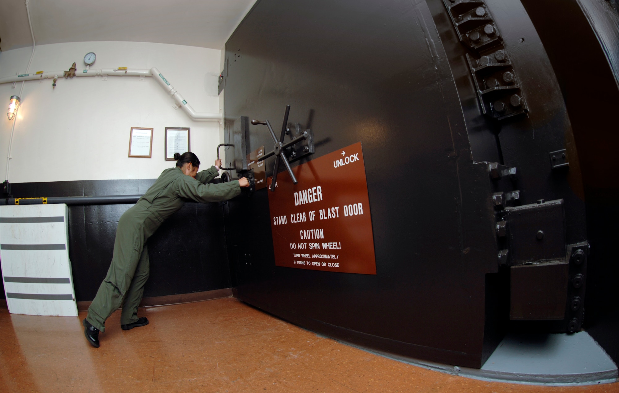 Underground at Minot Air Force Base's Missile Alert Facility B-1, one of 15 91st Space Wing MAFs scattered across northwest North Dakota, 1st Lt. Theresa Lau closes the outer blast door Aug. 18.  The 10-ton door permits access to the launch control center where the missile combat crew on duty controls and monitors Minuteman III missiles in dispersed underground launch facilities.  Lieutenant Lau is a missile combat crew deputy commander with the 740th Missile Squadron.  (U.S. Air Force photo/Master Sgt. Lance Cheung) 