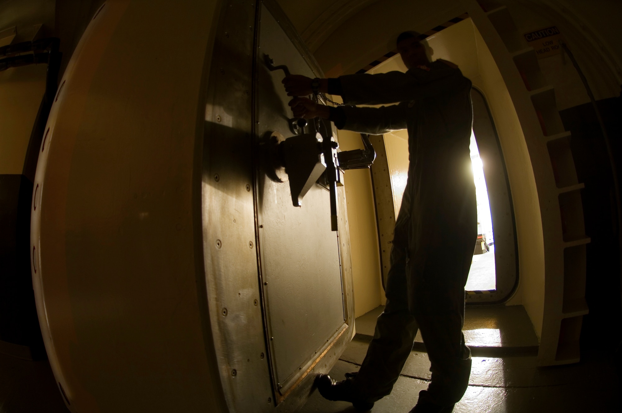 Underground at Minot Air Force Base's Missile Alert Facility B-1, one of 15 91st Space Wing MAFs scattered across northwest North Dakota, 2nd Lt. Trey Marshall prepares to close the launch control center blast door on Aug. 18.  The eight-ton door permits access into the launch control center where the missile combat crew on duty controls and monitors Minuteman III missiles in dispersed underground launch facilities.  Lieutenant Marshall is a missile combat crew deputy commander with the 740th Missile Squadron.  (U.S. Air Force 