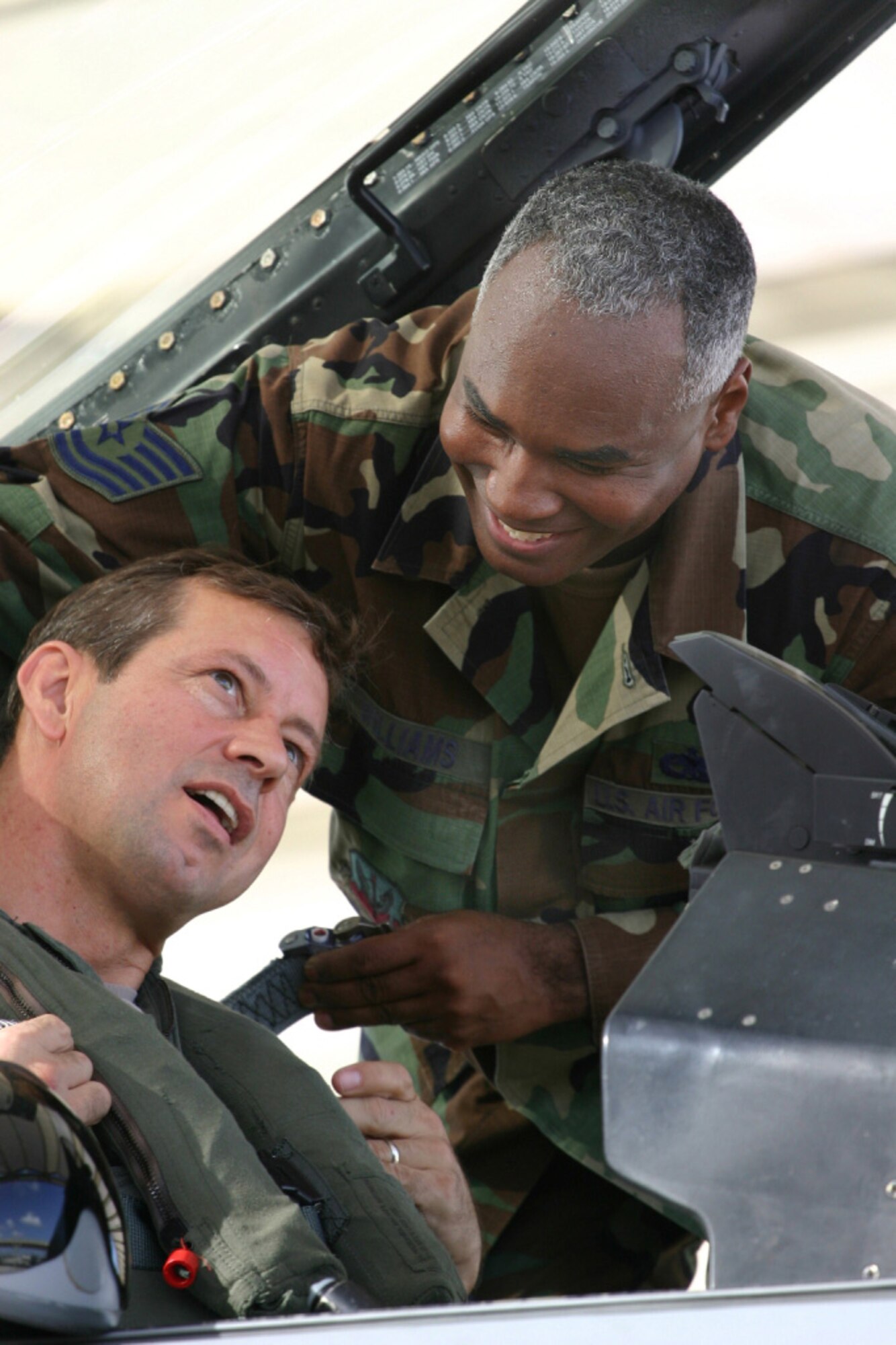 Tech. Sgt. Clive Williams straps Lt. Col. Scott Goodfellow into the cockpit of his F-16 prior to engine start on Aug. 11 here at Homestead Air Reserve Base, Fla. Lt. Col. Goodfellow, fellow pilots and maintainers headed to Hickam Air Force Base to train with the Hawaii Air National Guard in exercise Cactus Aloha. (US Air Force photo by Tech. Sgt. Bucky Parrish)
