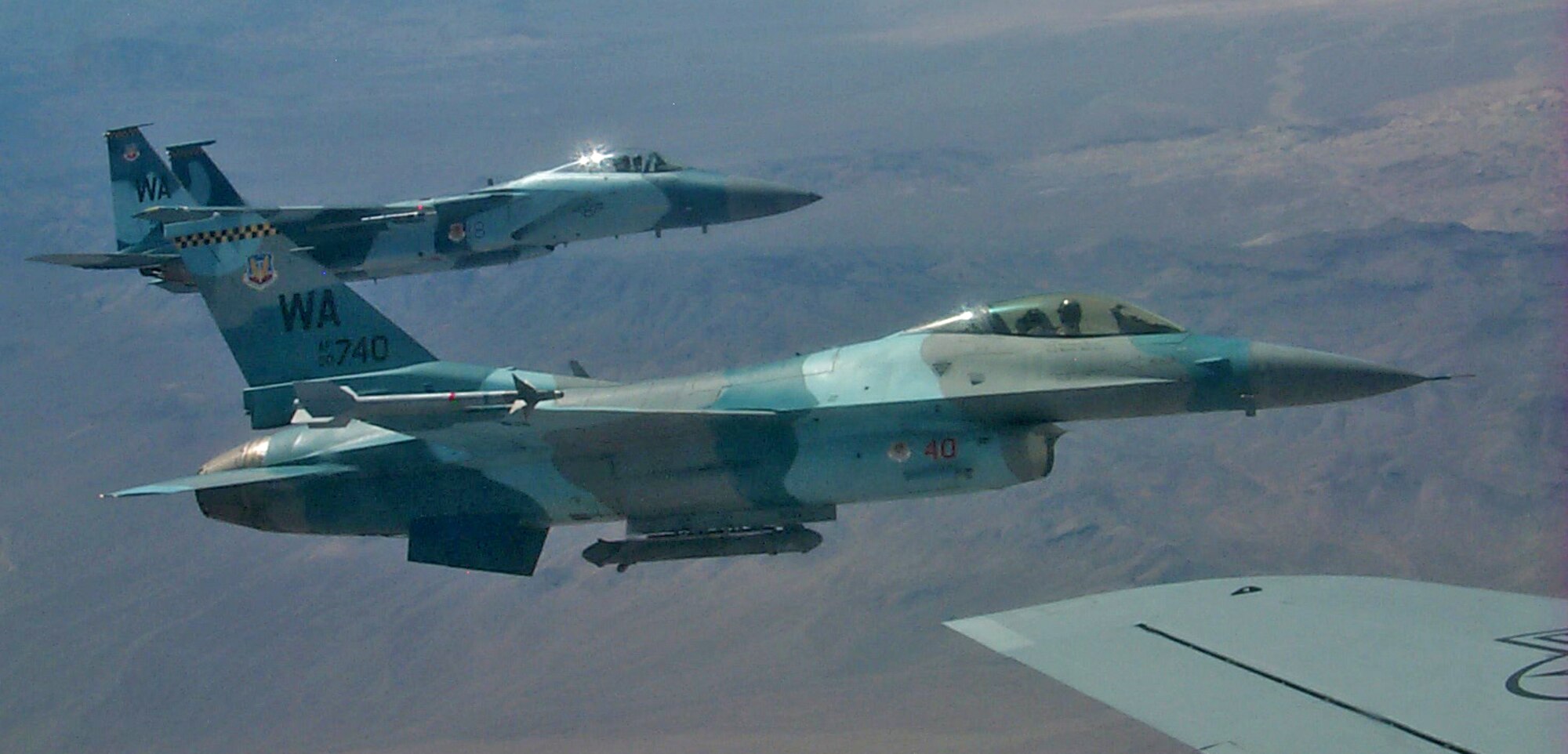 F-16 and F-15 Aggressor aircraft from Nellis AFB, Nev., fly in formation with a KC-135 tanker from the 6th Air Mobility Wing, MacDill AFB, Fla., Aug. 18. The Aggressors act as "enemy" aircraft during the Red Flag exercise which continues through Sept. 2. The F-15 Aggressors belong to the 65th Aggressor Squadron, while the F-16s belong to the 64th Aggressor Squadron. (U.S. Air Force photo/Mike Estrada)