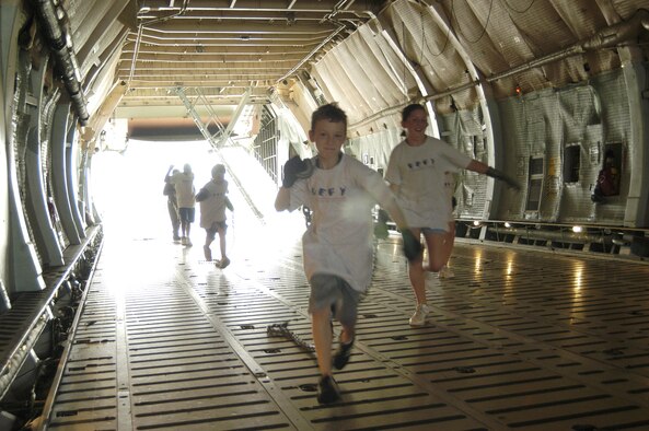 Dominic O’Donnell and Brianna Kinnari, Drug Education for Youth participants at Dover Air Force Base, Del., burn some extra energy Tuesday morning as they race through the cargo area of a C-5, while dragging chains used to tie down cargo during a tour on the flightline here recently. DEFY is a leadership and mentorship program created by the Department of Defense in 1993 to combat high rates of substance abuse. (U.S. Air Force photo/Airman 1st Class James Bolinger)                              