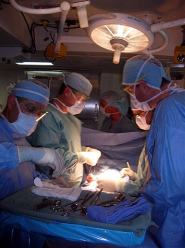 U.S. Navy Lt. Cmdr. Gordon Wisbach and his surgical team from Fleet Surgical Team 5 perform an emergency appendectomy aboard the USS Boxer (LHD 4) on a sailor from the USS Howard (DDG 83) while the ships operate in the Pacific Ocean on Aug. 13, 2006.  