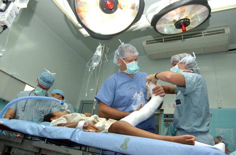 Lt. Col. (Dr.) Eric Ritchie (left) and Staff Sgt. Jolie Zygulski wrap a cast molding around the leg of a patient after successful surgery Aug. 15 at the Hospital Esquela in Tegucigalpa, Honduras. A medical team of eight people from Wilford Hall Medical Center at San Antonio and Joint Task Force-Bravo at Soto Cano Air Base, Honduras, treated more than 200 people and operated on more than 60 individuals during its two-week training exercise Aug. 5 to 19. Colonel Ritchie and Sergeant Zygulski are from the Wilford Hall Medical Center, San Antonio. (U.S. Air Force photo/Senior Airman Mike Meares) 
