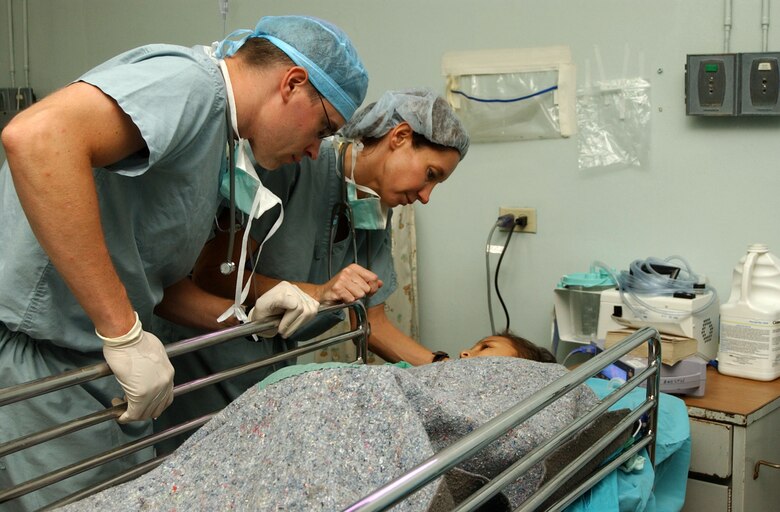 Maj. (Dr.) Christopher James, anesthesiologist, and Maj. Elizabeth Cooley, recovery room nurse, tend to a 9-year-old boy Aug. 15 at the Hospital Esquela in Tegucigalpa, Honduras. The boy had damage to his right leg from an infection. A medical team of eight people from Wilford Hall Medical Center at San Antonio and Joint Task Force-Bravo at Soto Cano Air Base, Honduras, treated more than 200 people and operated on more than 60 individuals during its two-week training exercise Aug. 5 to 19. Major James is an anesthesiologist and Major Cooley is a recovery room nurse. (U.S. Air Force photo/Senior Airman Mike Meares) 
