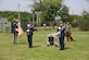McGuire Honor Guard members stand before “The Empty Dog” display that signifies the bond between a handler and his dog. Behind them stands Airman Vollweiler and his dog, Black, during the K-9’s retirement ceremony. Black and two of his fellow K-9s were adopted by their former handlers and went home with them after the ceremony.