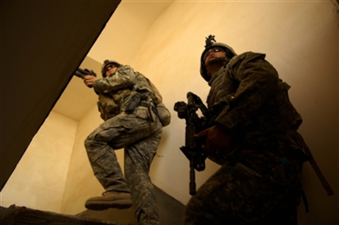 Soldiers climb a stair well as they clear a house during a patrol in Tall Afar, Iraq, on Aug. 18, 2006.  The soldiers are from the 1st Brigade Combat Team, 2nd Battalion, 37th Armored Regiment, 1st Armored Division.  