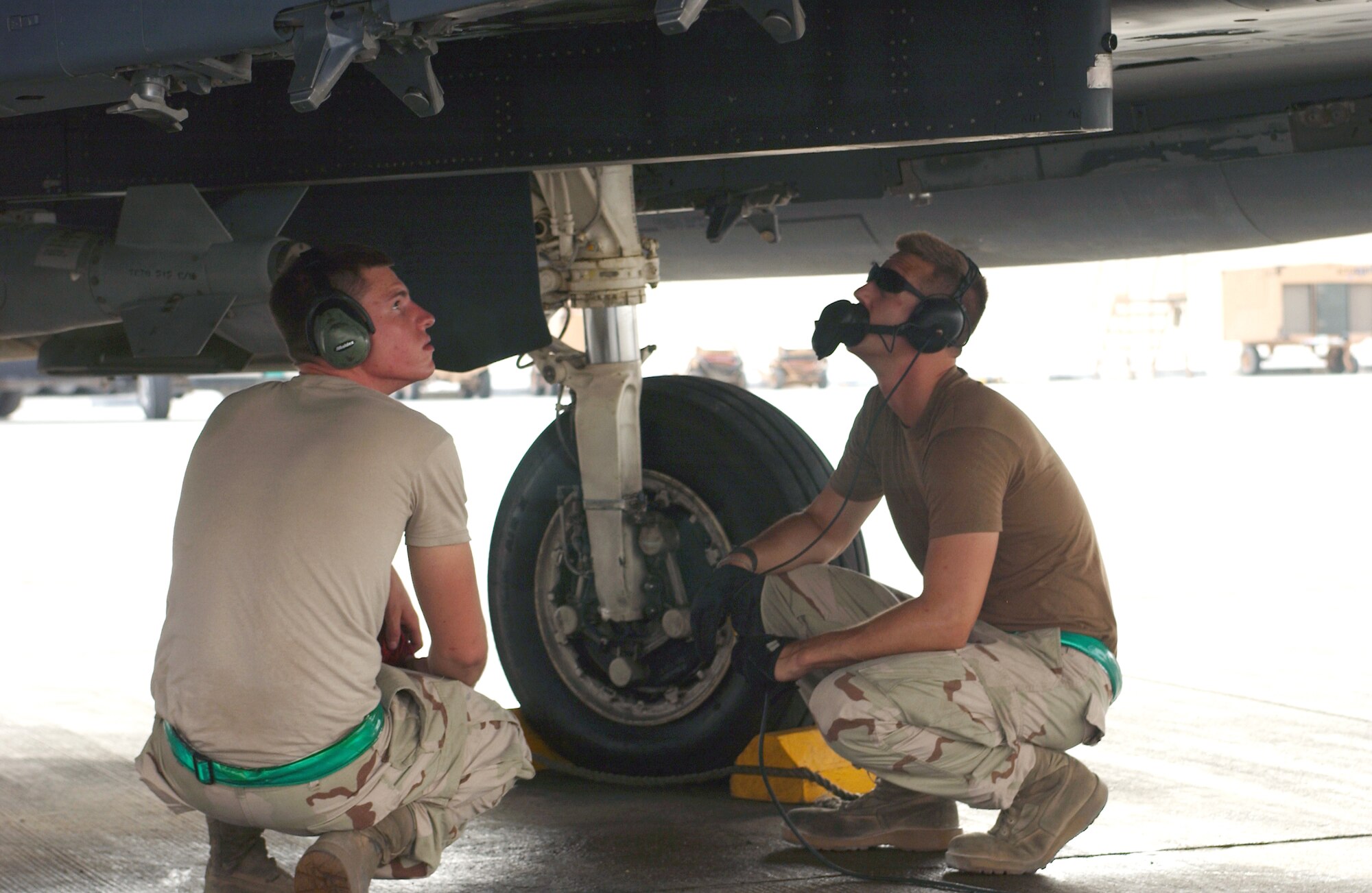 Senior Airmen Harlen Magnie and Wesley Hansard inspect their F-15E Strike Eagle during an engine-running preflight before a combat mission from a forward operating base in Southwest Asia Aug. 18. The Airmen are assistant crew chiefs deployed to the 379th Expeditionary Aircraft Maintenance Squadron from Seymour Johnson Air Force Base, N.C. (U.S. Air Force photo/Master Sgt. John DeGroot) 