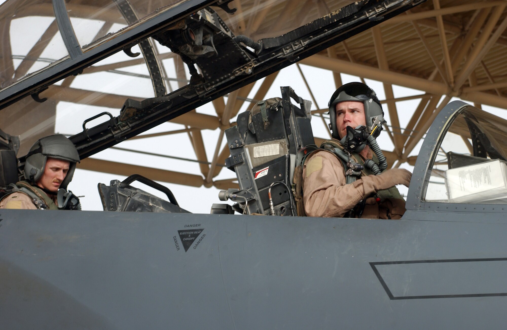 Maj. Jeff O'Donnell lowers the cockpit canopy as 1st Lt. Nathan Rivinius goes over his checklist before a combat mission from a forward operating base in Southwest Asia Aug. 18. Major O'Donnell is a pilot and Lieutenant Rivinius is a weapons systems officer. They are deployed to the 335th Expeditionary Fighter Squadron from Seymour Johnson Air Force Base, N.C. (U.S. Air Force photo/Master Sgt. Dutch DeGroot)
