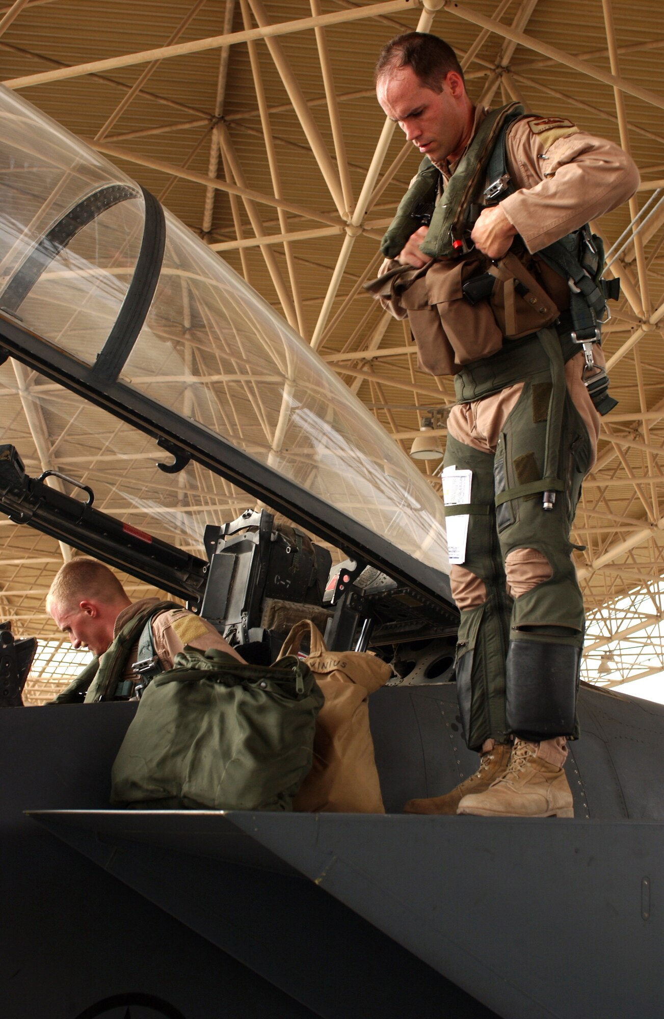 Maj. Jeff O'Donnell prepares to climb into the cockpit of his F-15E Strike Eagle while 1st Lt. Nathan Rivinius straps in before a combat mission from a forward operating base in Southwest Asia Aug. 18. Major O'Donnell is a pilot and Lieutenant Rivinius is a weapons systems officer. They are deployed to the 335th Expeditionary Fighter Squadron from Seymour Johnson Air Force Base, N.C. (U.S. Air Force photo/Master Sgt. John DeGroot)
