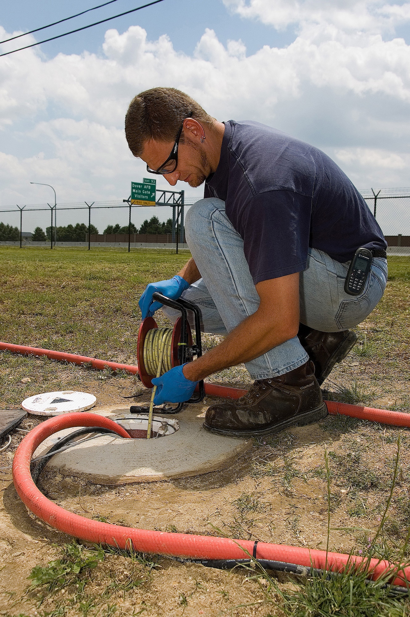 Rob Young, an Oak Ridge National Laboratory field technician for URS Corp, is taking a water level measurement from an extraction well.  The well is located near the base perimeter fence line adjacent to Route 1. URS Corp has worksites on Dover Air Force Base, and is the lead contractor overseeing contamination cleanup at Dover. The base is on the Superfund cleanup list and is in the final phase of cleanup. The Air Force, Environmental Protection Agency, and the Delaware Department of Natural Resources and Environmental Control have partnered together to cleanup contaminated areas around the base. (U.S. Air Force photo/Roland Balik)
