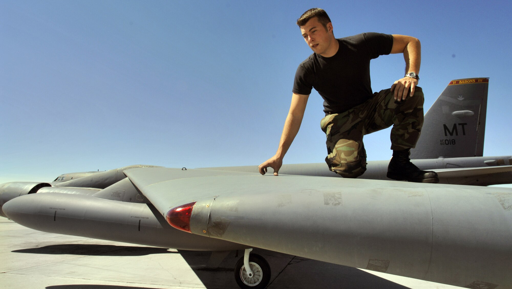 Staff Sgt. Kory McLeod inspects the wing tip of a B-52 Stratofortress at Minot Air Force Base, N.D., Aug. 22. The wings are more than 90 feet long and designed to bend with the weight of fuel and weapons. While on the ground, a wingtip wheel gear bears the weight. Sergeant McLeod, from Manchester, N.H., is a crew chief with the 5th Aircraft Maintenance Squadron. (U.S. Air Force photo/Master Sgt. Lance Cheung)