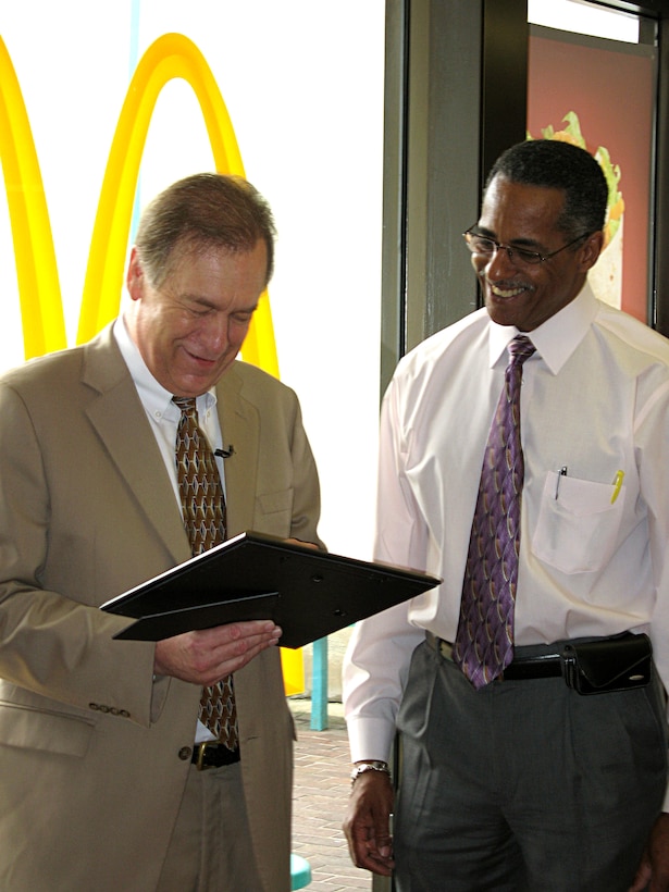 A Washington-area McDonald’s restaurant honored Jim Mayer (left), also known as the “Milkshake Man,” for providing Walter Reed Army Medical Center patients with McDonald’s milkshakes. McDonald’s David DeLacy, director of operations for the McDonald’s restaurant (right), presented Mayer with $250 in Arch gift cards and a McDonald’s “Most Valuable Customer” certificate during the Aug. 22 recognition ceremony. Photo by Samantha L. Quigley