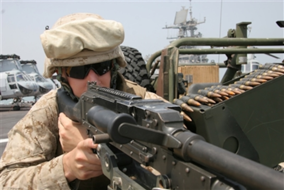 U.S. Marine Corps Lance Cpl. Corey Chiappazzi, a native of Erie, Pa., scans the horizon over the sites of his M240G medium machine gun on the flight deck of the USS Iwo Jima as it sails through the Suez Canal on its way to the Central Command theater of operation, Aug. 20, 2006. 