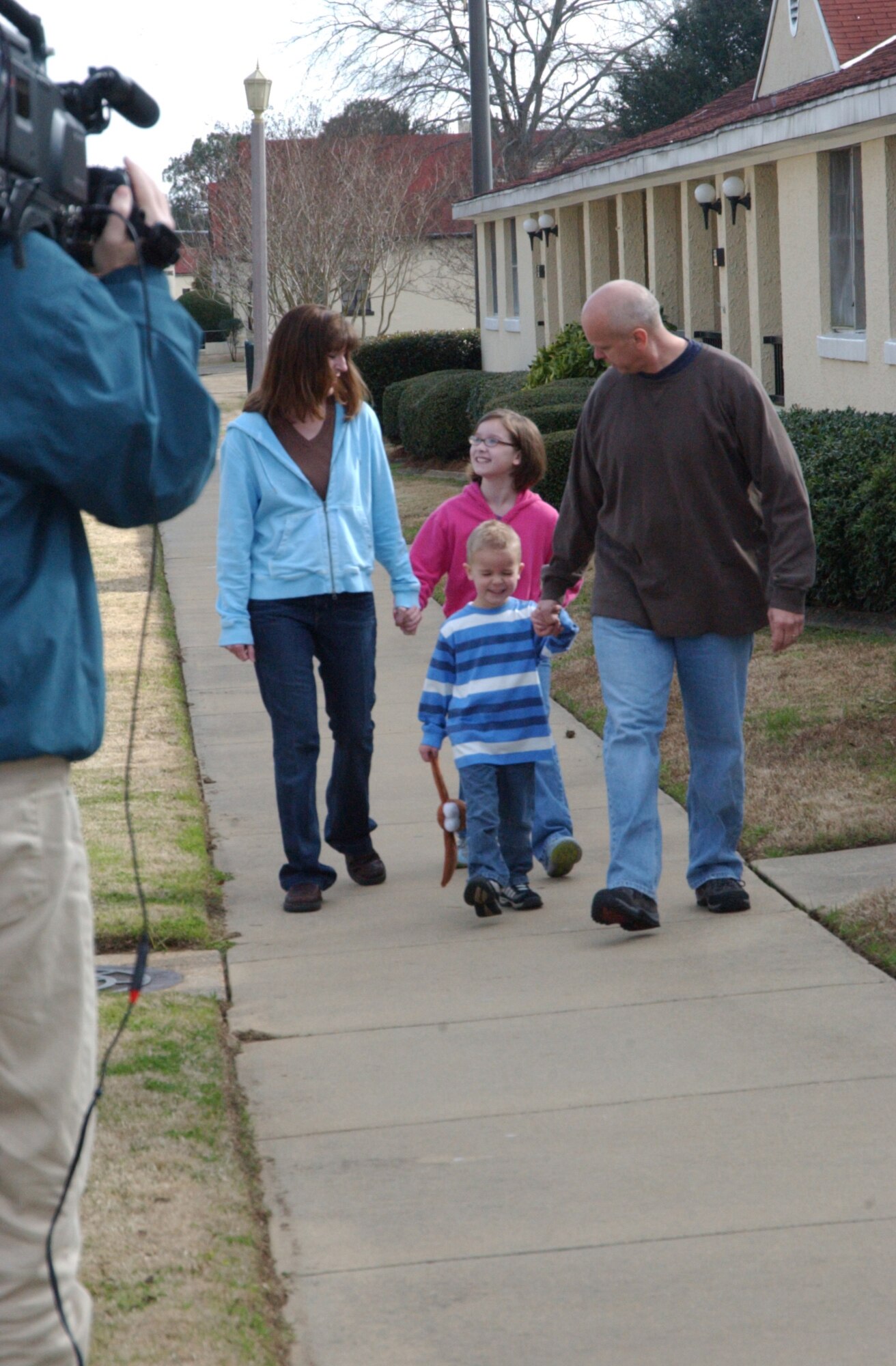 House Hunters cameraman Spencer Cooper collects footage of the Day family, Diane, Sarah Jo, Jacob, and Senior Master Sgt. Greg Day in front of their temporary living facility at Maxwell Air Force Base, Ala. The House Hunters’ profile of the Days is scheduled to air this fall on Home and Garden Television. (U.S. Air Force photo by Tech. Sgt. Scott Moorman)