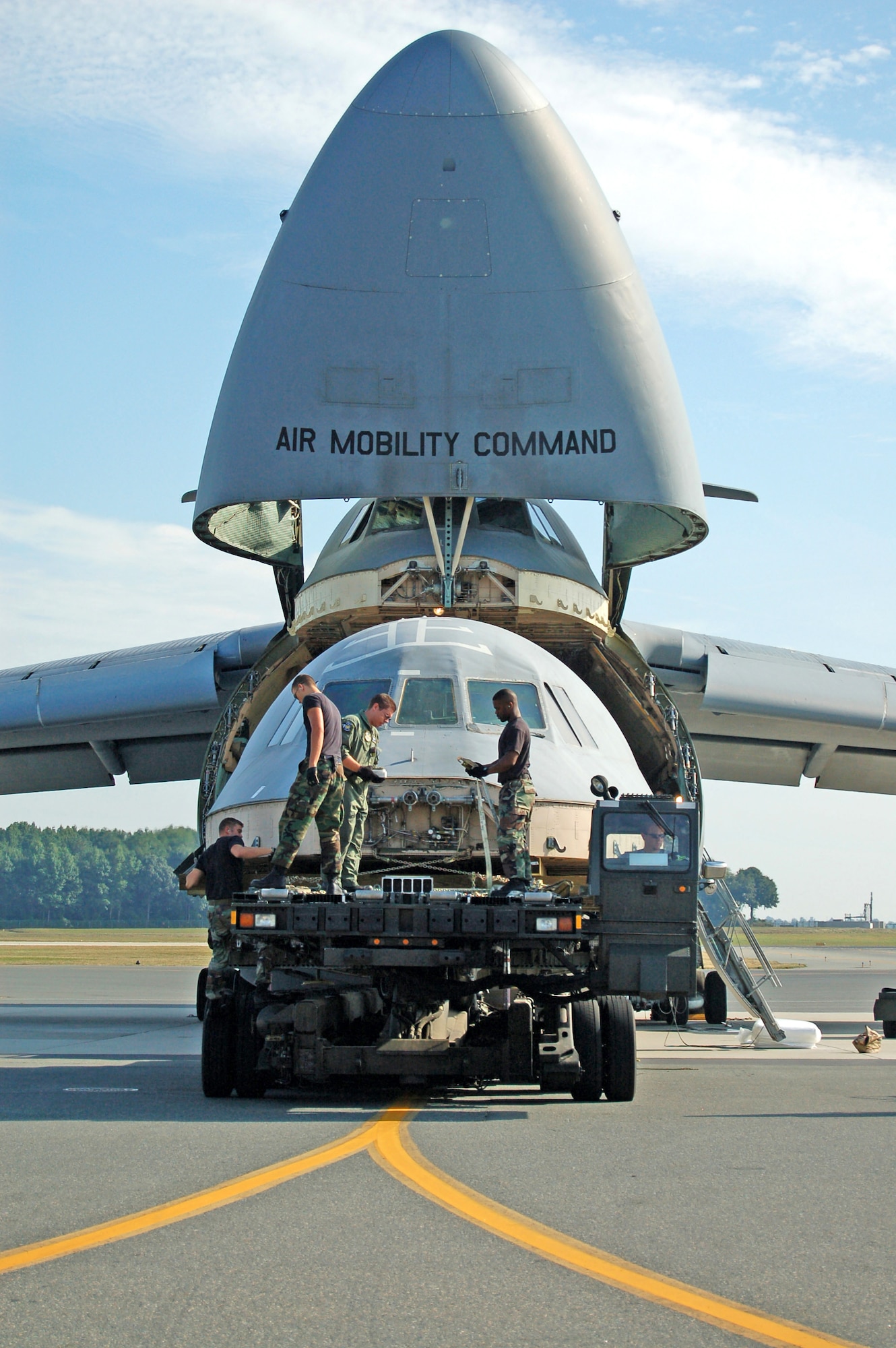 (Left to right) Staff Sgt. John Rollins, Airman 1st Class Shain Brower, Staff Sgt. Stuard Smith II and Senior Airman Joseph Moseley load a C-5 Galaxy flight deck onto another C-5 for transport to Robins Air Force Base, Ga. The flight deck from the C-5 that crashed April 3 will be used to as a training simulator. Sergeant Rollins and Airmen Brower and Moseley are assigned to the 436th Aerial Port Squadron; Sergeant Smith is with the 9th Airlift Squadron. (U.S. Air Force photo/Airman 1st Class James Bolinger)
