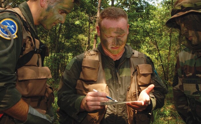 Capts. Steven Wick (left) and Ron Schochenmaier (center), 14th Airlift Squadron pilots, and Tech. Sgt. Iain Stewart (right), 437th Operations Support Squadron SERE specialist, participate in combat survival training Aug. 1. The refresher training, taught by Sergeant Stewart, helped aircrew members practice their navigational skills and teamwork and stay proficient in survival skills. (U.S. Navy photo by Photographer's Mate 2nd Class Christopher Perez)