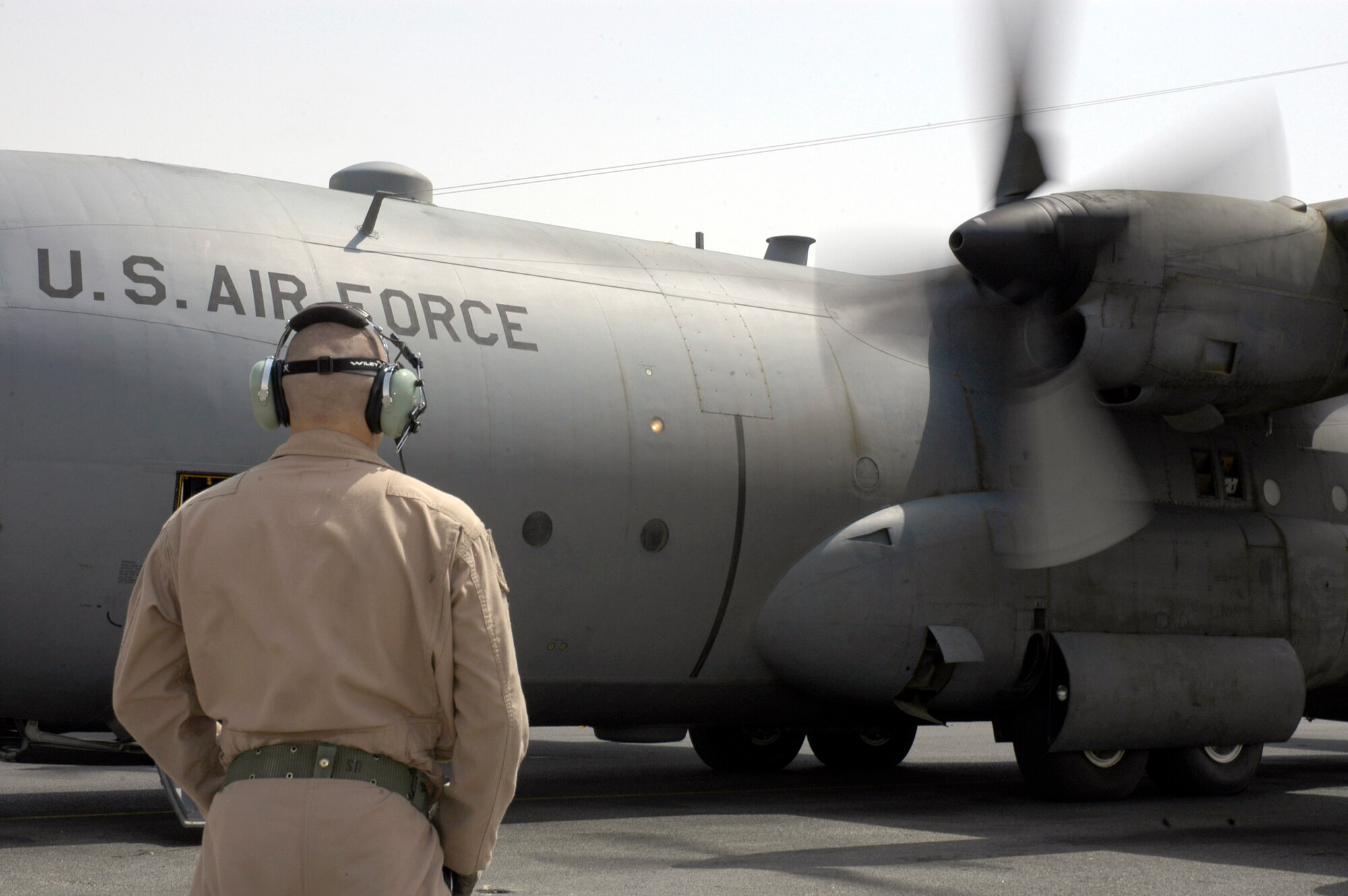 A loadmaster with the 738th Expeditionary Airlift Squadron watches as the aircraft commander fires up the engine of a C-130 Hercules at a forward operating base in Southwest Asia Aug. 23. The 738th EAS is part of the 386th Air Expeditionary Wing, which is the primary aerial hub for Operation Iraqi Freedom and provides airlift support for Operation Enduring Freedom and the Horn of Africa. (U.S. Air Force photo/Staff Sgt. Ryan Hansen)

