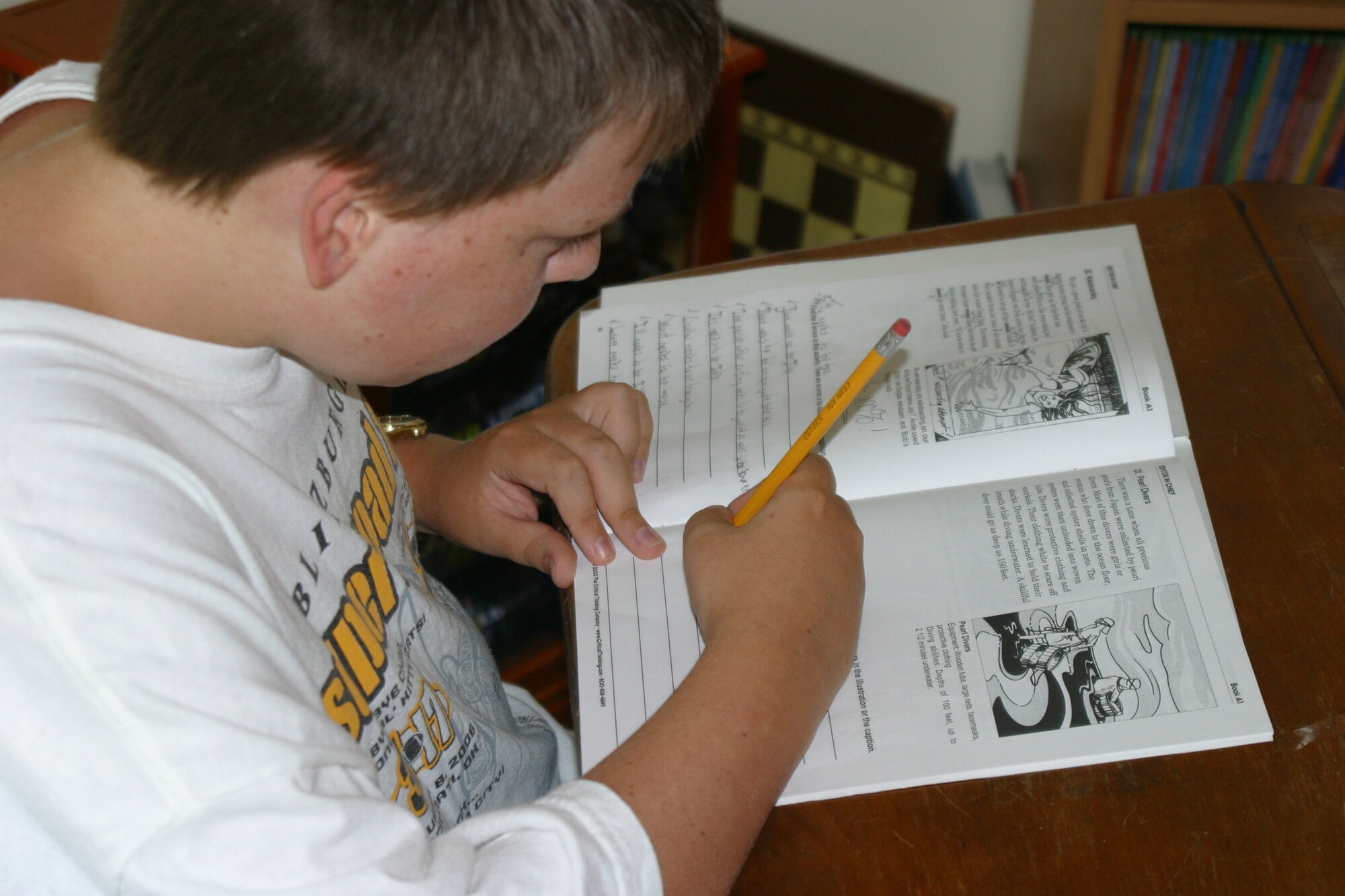 Ben Bahrenfull, son of master Sgt. Brian Bahrenfuss of the 18th Air Support Operations Group, completes a lesson at his desk at home. Ben has been homeschooled for five years.