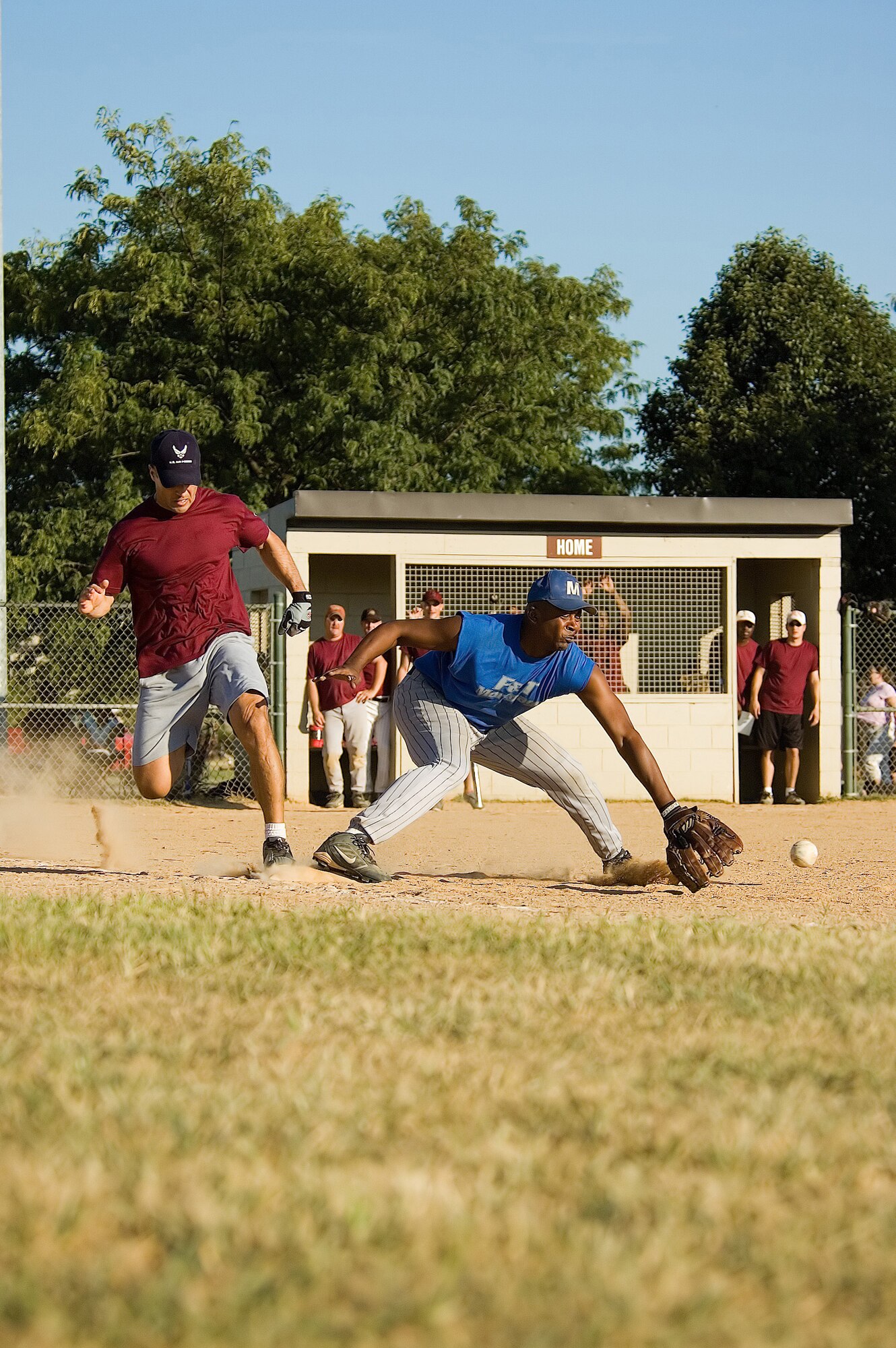 Jim Foltz (left), 436th Medical Group first baseman, runs across first base as KC, 436th Logistics Readiness Squadron first baseman, awaits the ball. The Medics defeated the Loggies 6 - 2 in seven innings, despite not scoring until the sixth inning.