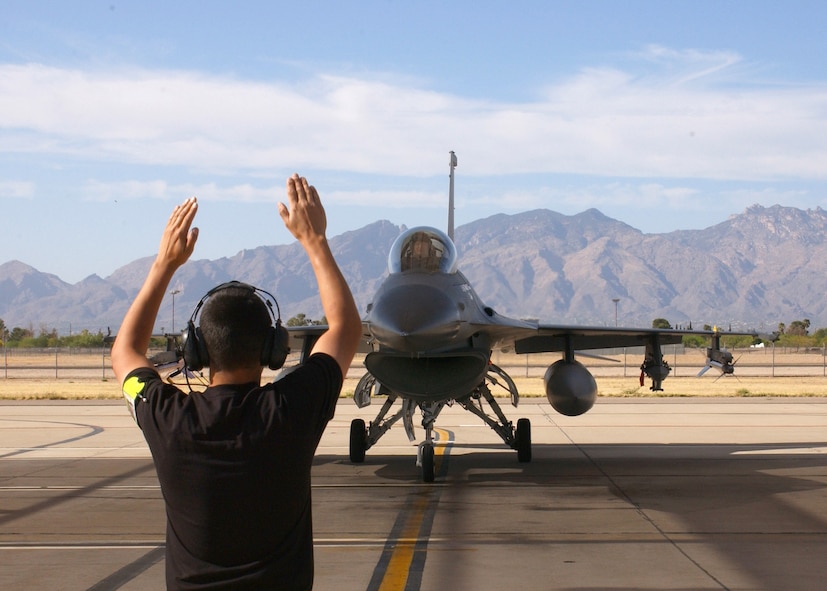 DAVIS-MONTHAN AFB, Ariz. -- Staff Sgt. Christopher Cortez, a crew chief with the 149th Aircraft Maintenance Squadron, guides instructor pilot Maj. Mark Jennings on the ramp here during exercise Coronet Cactus 2006 in April. Two hundred-thirty members of the 149th Fighter Wing deployed to Tucson to conduct training that included dropping heavy ordnance, both live and inert, on the Barry Goldwater Bombing Range. (Texas Air National Guard photo by Master Sgt. Rene Castillo)