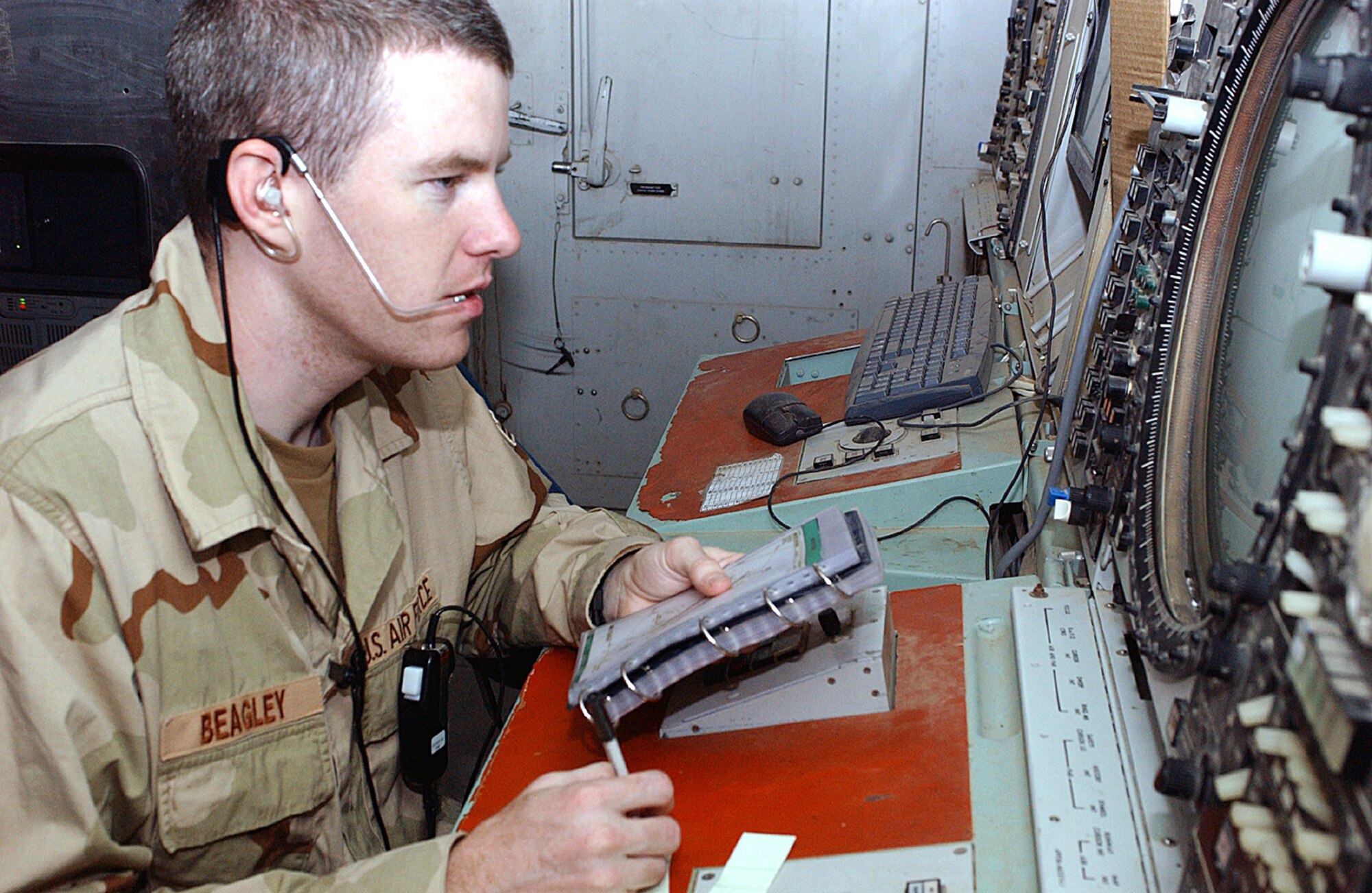 ALI BASE, Iraq -- Senior Airman Joshua Beagley, 407th Expeditionary Operations Support Squadron, runs a checklist as he controls the air space over Southern Iraq from the Area Control Center here. Each month, the center controls more than 10,000 aircraft in a 200-mile radius around Ali.  (Photo by Master Sgt. Andrew Gates)