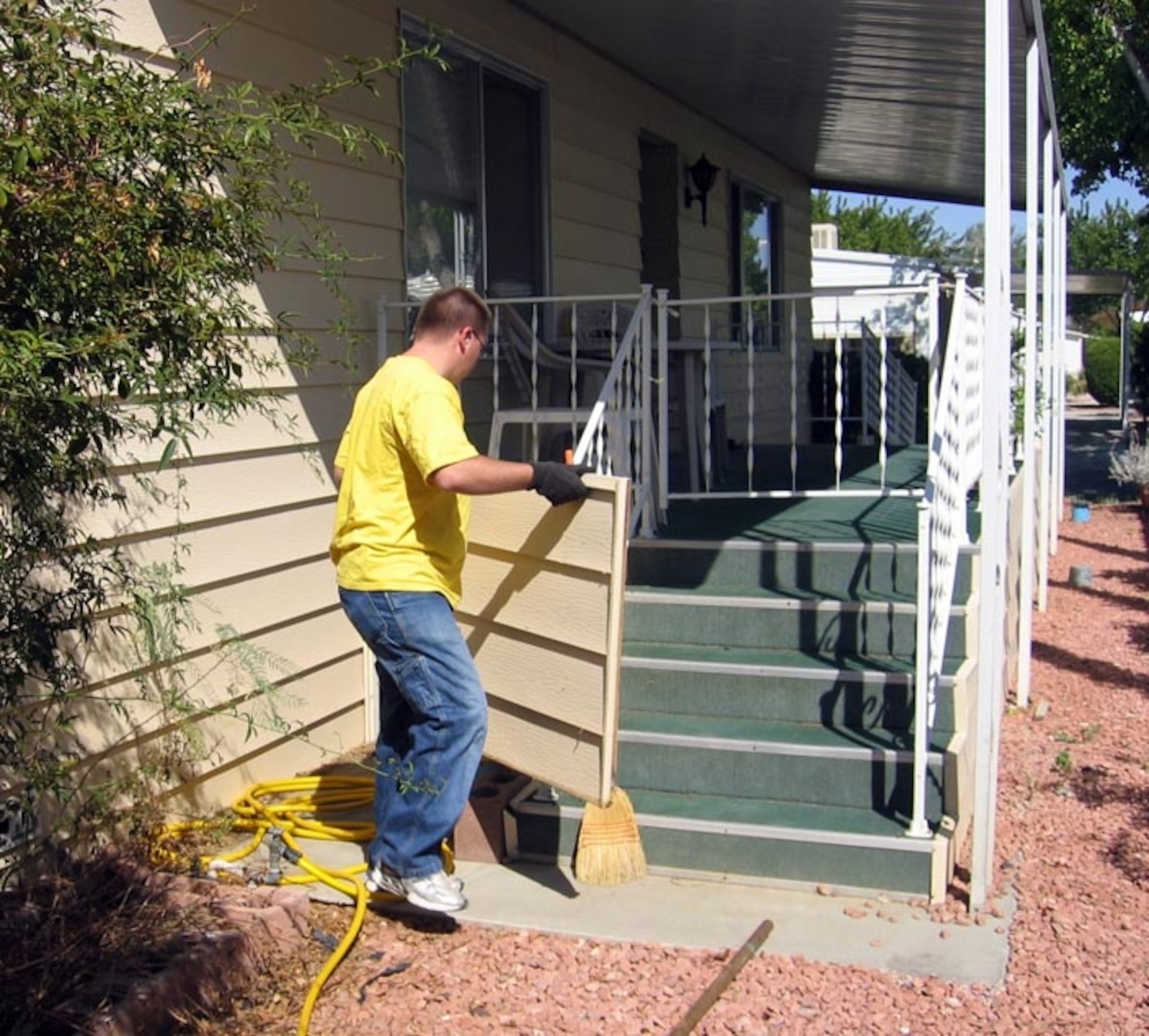 Airman 1st Class Jonathan Tuck removes and cleans vinyl siding for a senior citizen in Lancaster, Calif.  Airman Tuck, a missile maintenance crew member assigned to the 412th Maintenance Squadron, is a volunteer with the Honey Do Program at Edwards Air Force Base, Calif. Volunteers offers monthly services for senior citizens who can no longer do the work themselves or afford to pay for the maintenance. (U.S. Air Force photo/Staff Sgt. Jessie Gregorio) 