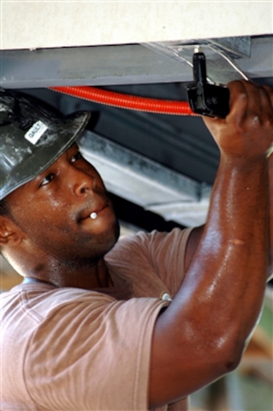 U.S. Navy Seabee Petty Officer 2nd Class Marshall Gault uses a rivet gun to attach metal bracing during a construction project in San Fernando, Philippines, on Aug. 9, 2006. Gault and his fellow Seabees from Naval Mobile Construction Battalion 1 are deployed to the Philippines to participate in Cooperation Afloat Readiness and Training, an annual series of bilateral maritime training exercises between the United States and six Southeast Asian nations.  