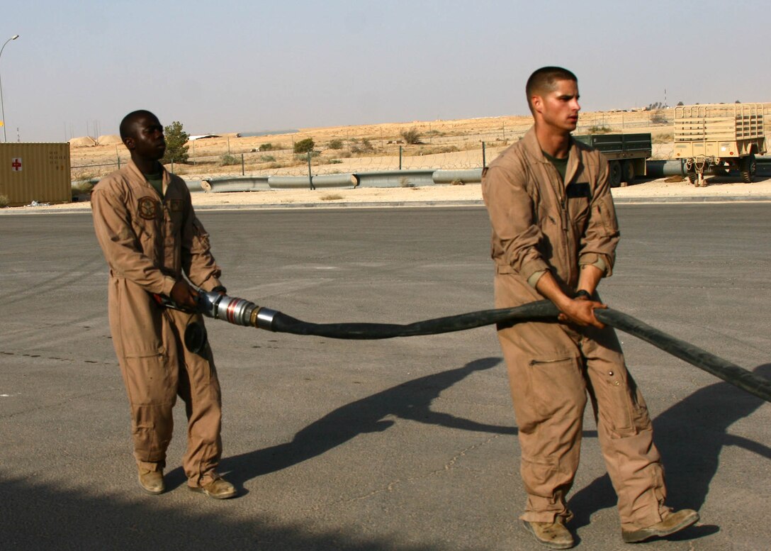 Cpl. Shawn N. Gibbons (left) and Cpl. Christopher J. Hartman pull a fuel line out of a fueling tanker Aug. 24, at Al Asad, Iraq. The Marines are motor transportation operators with mobile fuels section of Marine Wing Support Squadron 274, Marine Wing Support Group 37 (Reinforced), 3rd Marine Aircraft Wing. Gibbons is a native of Queens, N.Y., and Hartman is a native of Fredericksburg, Va.
