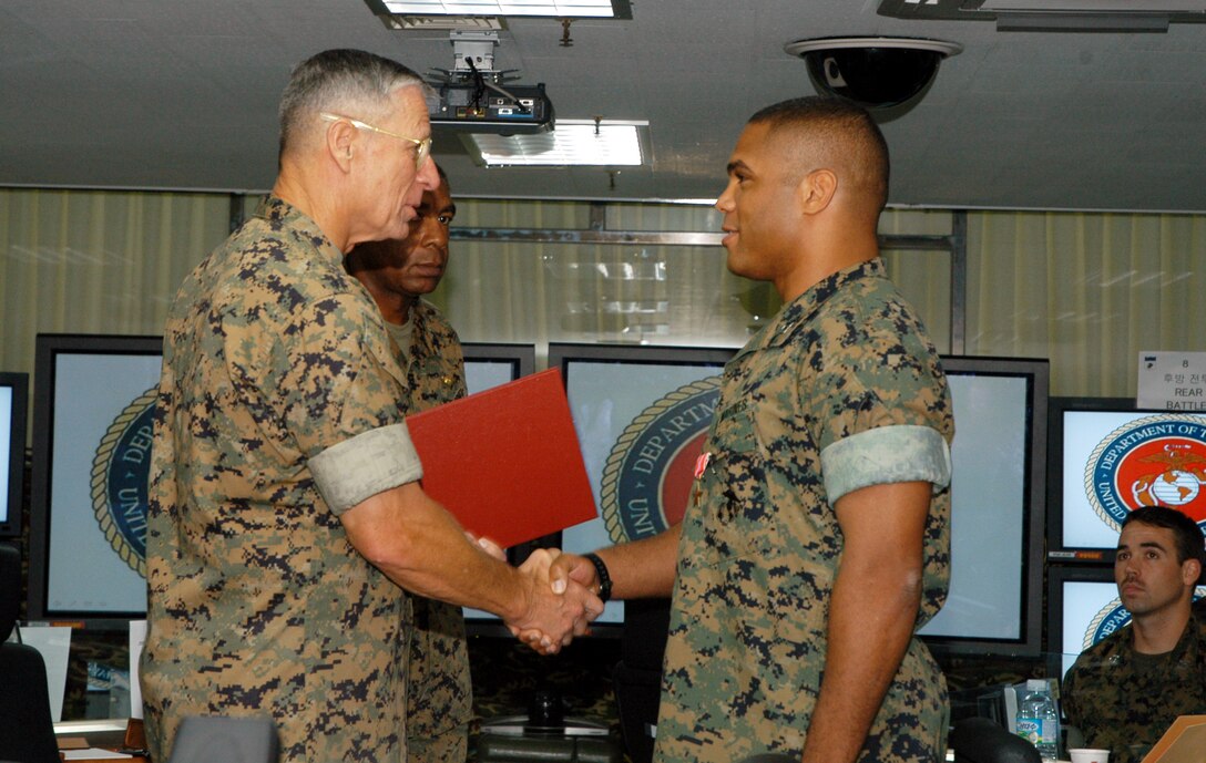 CAMP BARAN, South Korea -- Lt. Gen. John F. Goodman, commander, U.S. Marine Corps Forces, Pacific, (left) presents Capt. Kelly J. Grissom, intelligence officer, MFP, with the Bronze Star medal with combat distinguishing device, for his actions as company commander of Fox Company, 2nd Battalion, 3rd Marine Regiment, during their deployment in support of Operation Enduring Freedom in 2005. Grissom led his Marines during 'Operation Whalers,' through the Chawkay Valley of Afghanistan. Grissom and his company repelled multiple enemy assaults while coordinating close air support and other supporting arms. (Photo by Republic of Korea Marine Corps Gunnery Sgt. Jeongmim Jo)