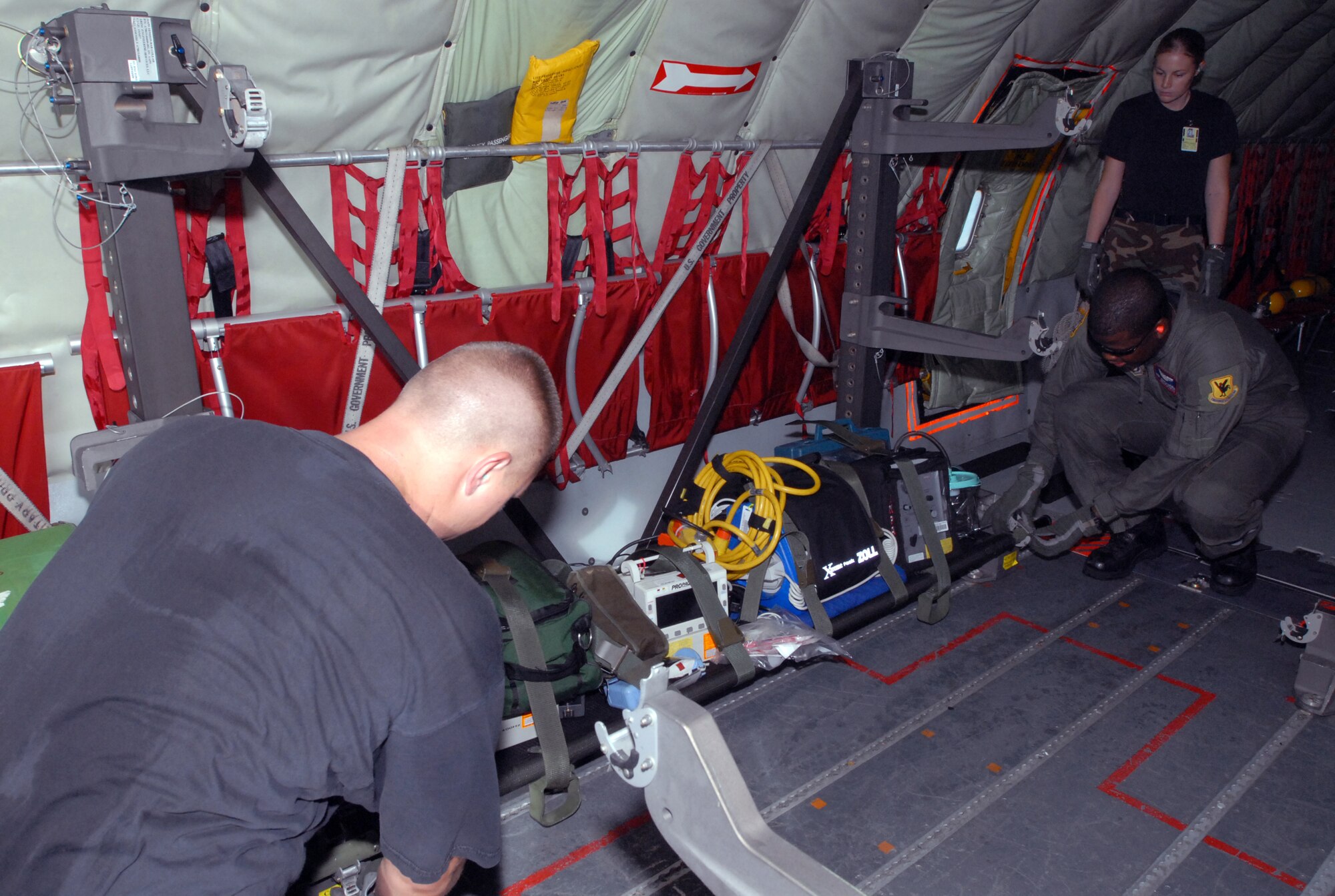 KADENA AIR BASE, Japan -- Staff Sgt. Joseph Lueders (left), Tech. Sgt. Kevin Mathews and 1st Lt. Kacey Hawley, 18th Aeromedical Evacuation Squadron, load and secure medical supplies into the cabin of a KC-135 Stratotanker prior to a flight to South Korea. The flight is for transporting patients who need assistance either at Kadena or other Pacific locations. (Air Force photo courtesy of 18th Wing Public Affaris)