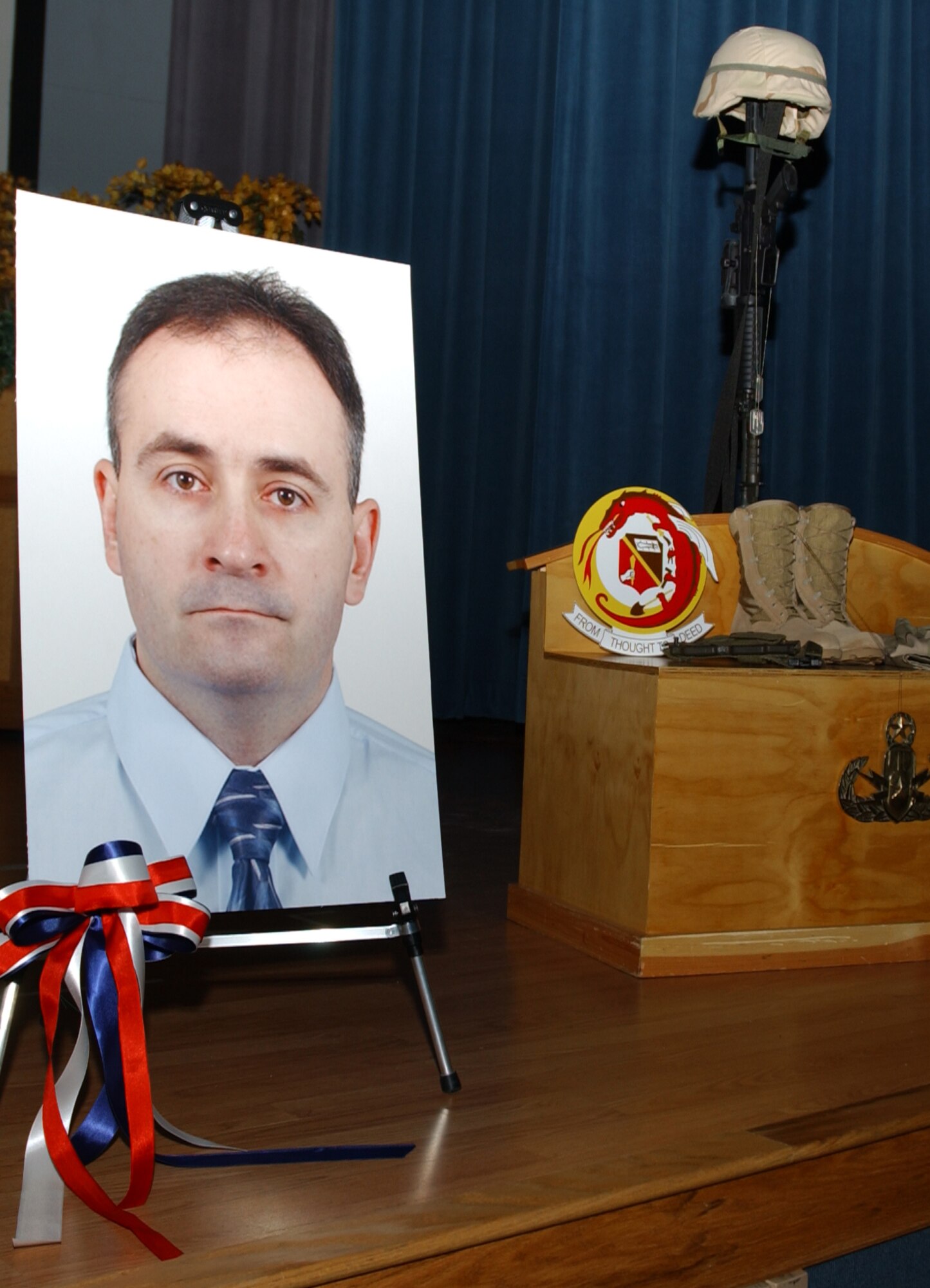 EIELSON AIR FORCE BASE, Alaska--A display honoring Master Sgt. Brad Clemmons, 354th Engineer Squadron explosive ordnance disposal craftsman, rests on the base theater stage during a memorial service here Thursday.  A capacity crowd of friends, family and fellow Icemen came together to pay tribute to Sergeant Clemmons, who lost his life Aug. 21 in support of Operation Iraqi Freedom while traveling in a convoy en route to Taji, Iraq, when his vehicle was struck by an improvised explosive device.  (U.S. Air Force photo by Airman Christopher Griffin)