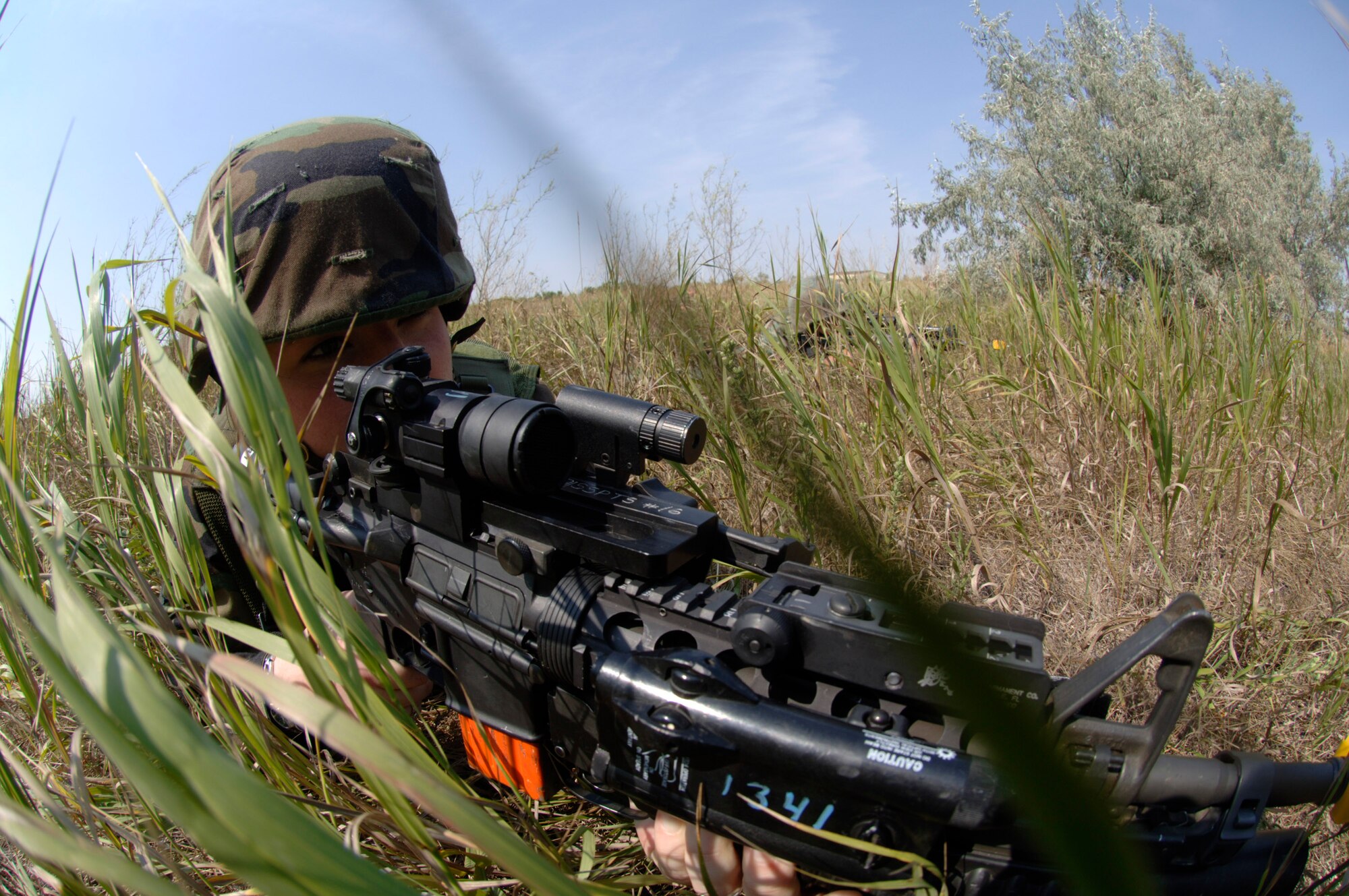 Senior Airman Melissa Philhower makes a tactical move during a coordinated security training exercise Aug. 22. The Airman from Orlando, Fla., is with the 91st Missile Security Squadron, Minot Air Force Base, N.D. Once in view of the facility, this team will form another 360 formation and provide outer area security while another team enters the facility. (U.S. Air Force photo/Master Sgt. Lance Cheung)