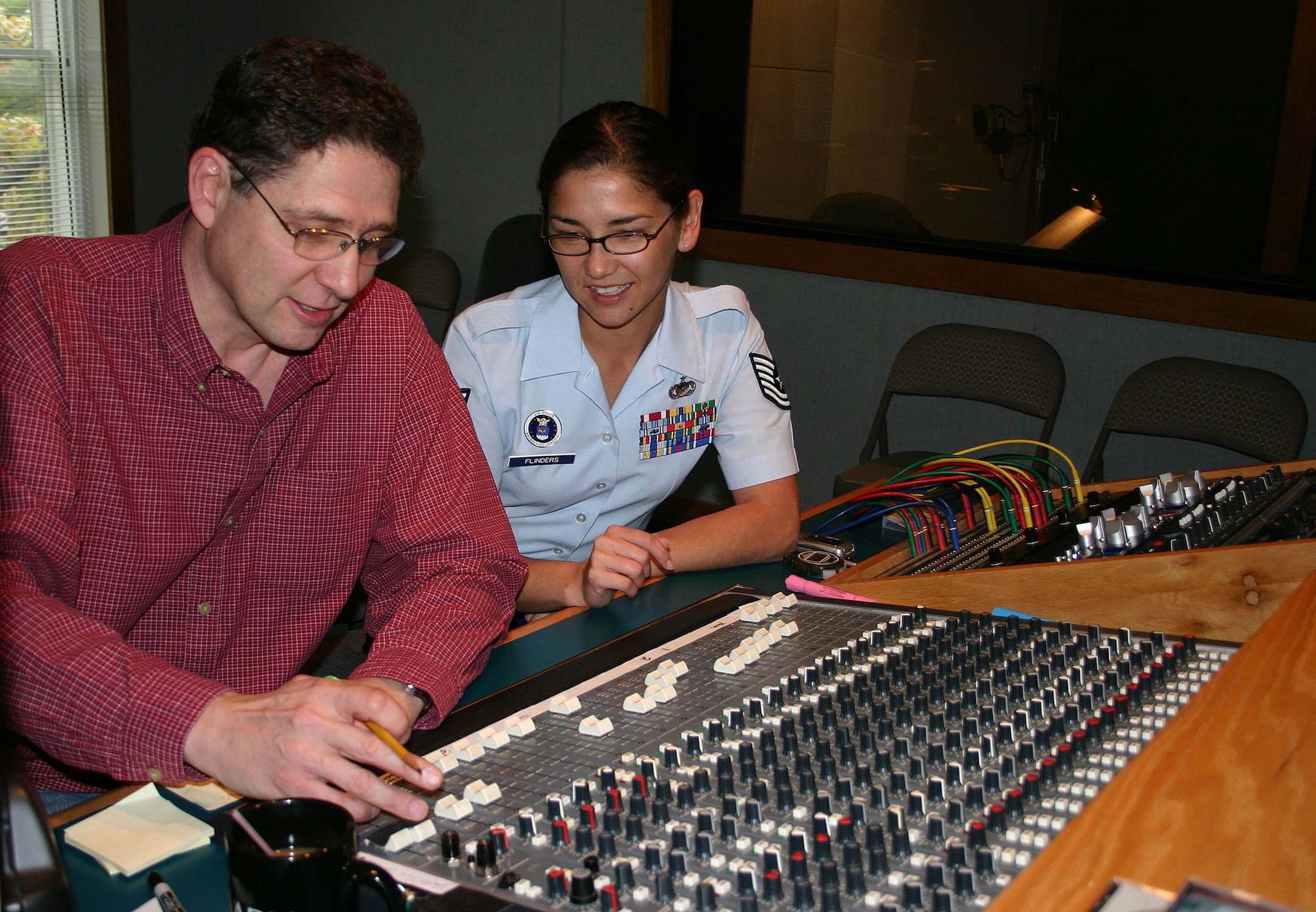 Tech. Sgt. Shiela Flinders, Headquarters Air Force Recruiting Service NCO in charge of broadcasting, and Ben Holland, of Spotland Productions in Nashville, mix production tracks for the 2005 Red, White and Air Force Blue Christmas radio show. The program features country music star Lee Ann Womack. (U.S. Air Force photo by Dale Eckroth)