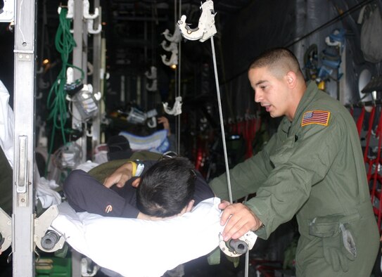 ANDREWS AIR FORCE BASE, MD. -- Staff Sgt. Keith Beckerich, 445th Aeromedical Evacuation Squadron, talks with a patient on a C-130.  Squadron members have been stationed here and are completing their fourth, four-month rotation this month as the primary AES for the distribution of patients returning to the United States from Ramstein Air Base, Germany. (U.S. Air Force photo by Master Sgt. Doug Moore).